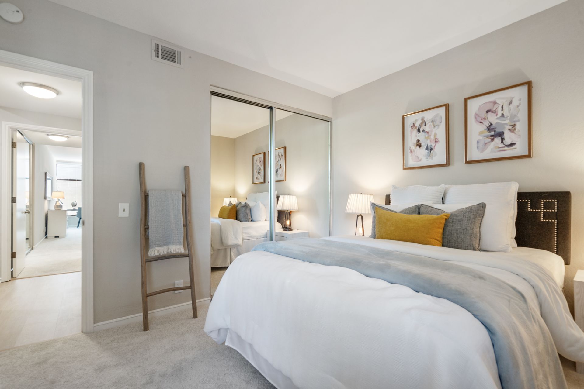 A bedroom with a king size bed and a ladder.