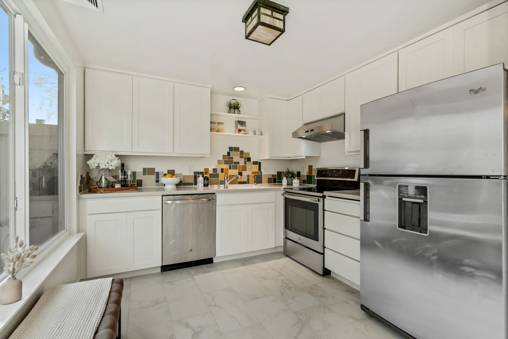 A kitchen with stainless steel appliances and white cabinets