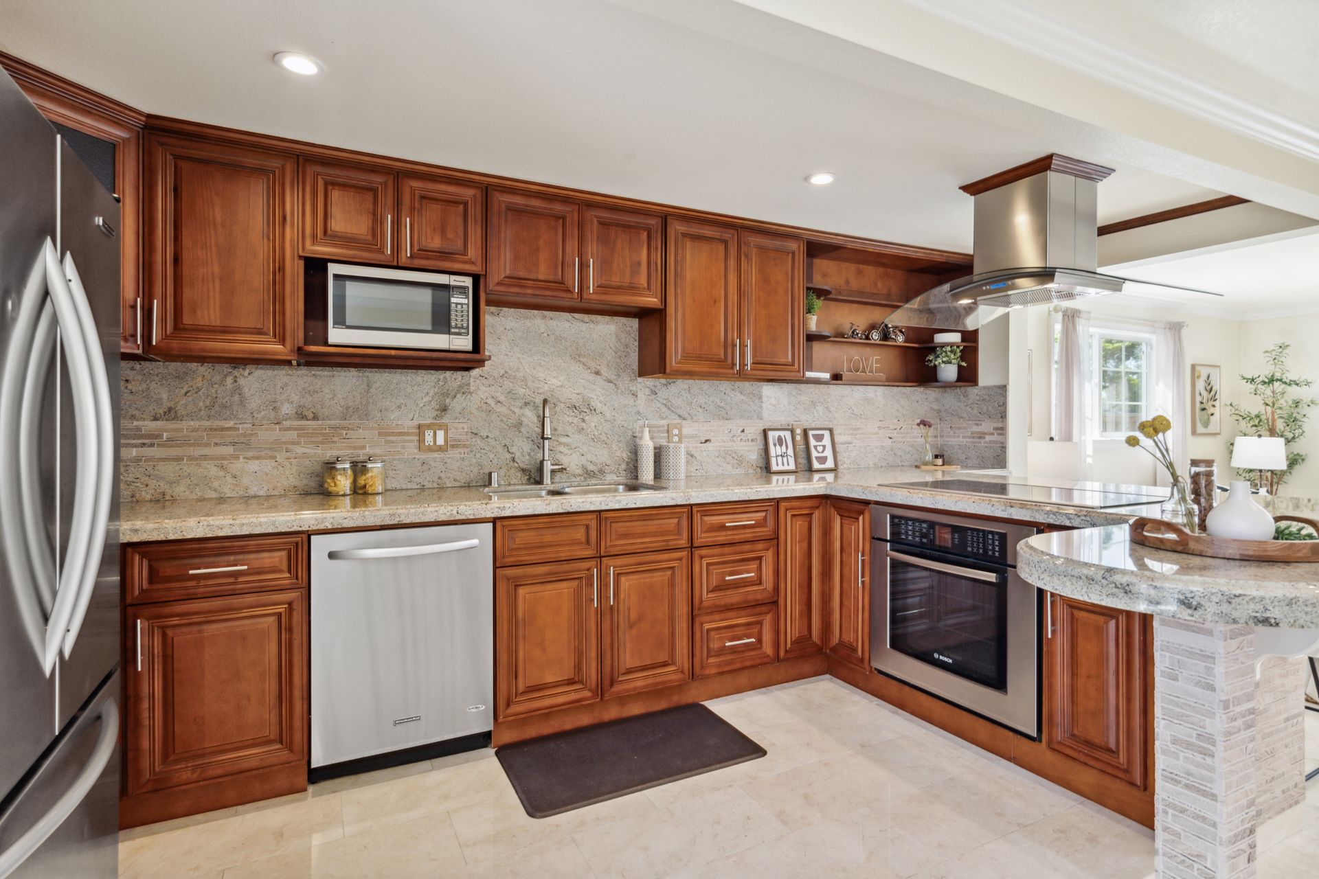 A kitchen with wooden cabinets , stainless steel appliances and granite counter tops.