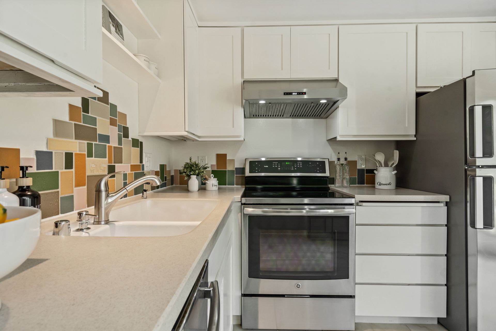 A kitchen with a stove , sink , refrigerator and microwave.
