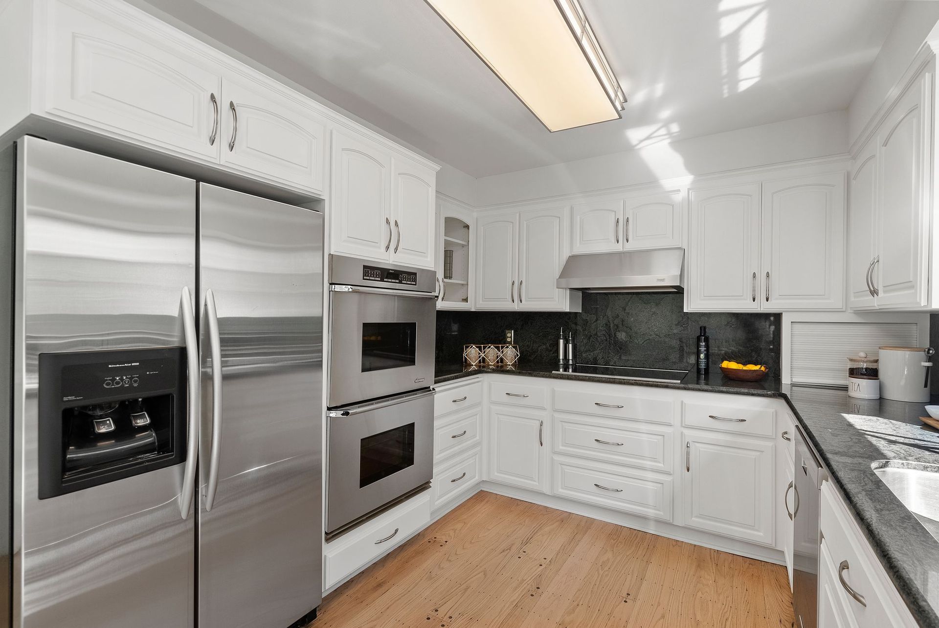 A kitchen with stainless steel appliances and white cabinets