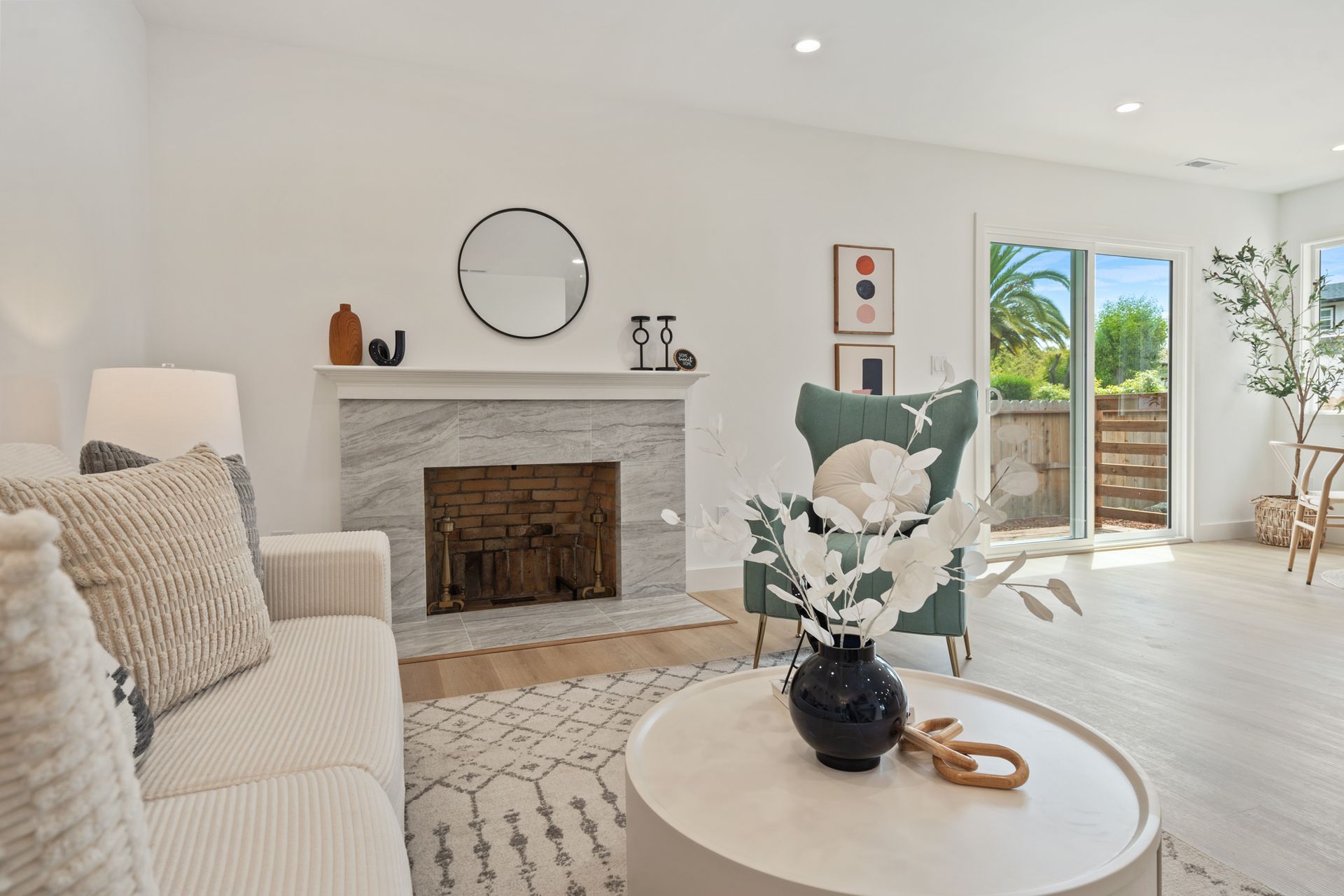 A living room with a couch , chair , coffee table and fireplace.