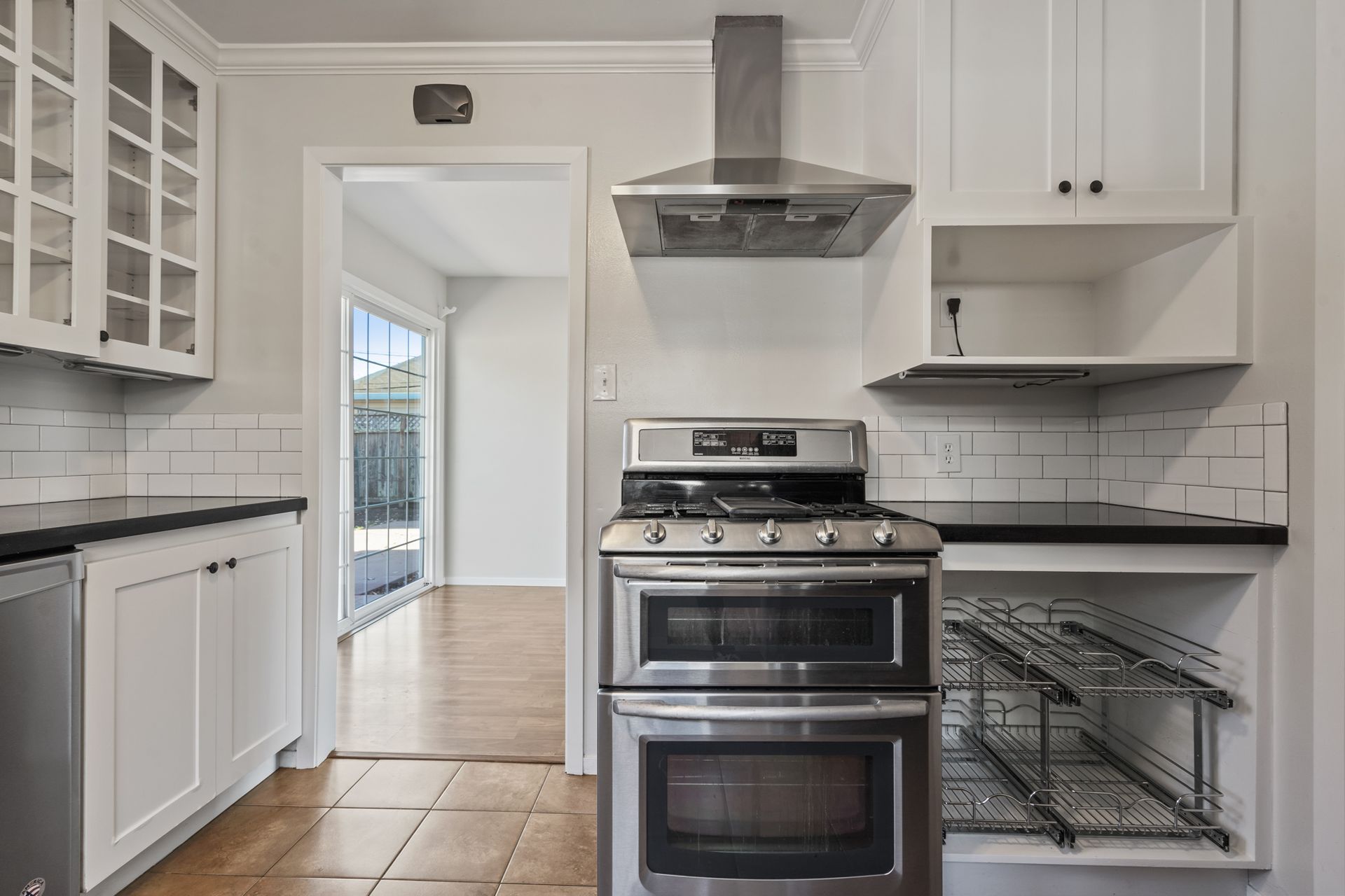 A kitchen with stainless steel appliances and white cabinets.