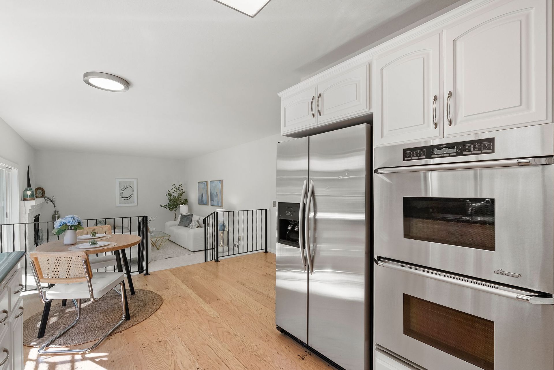 A kitchen with stainless steel appliances and white cabinets.