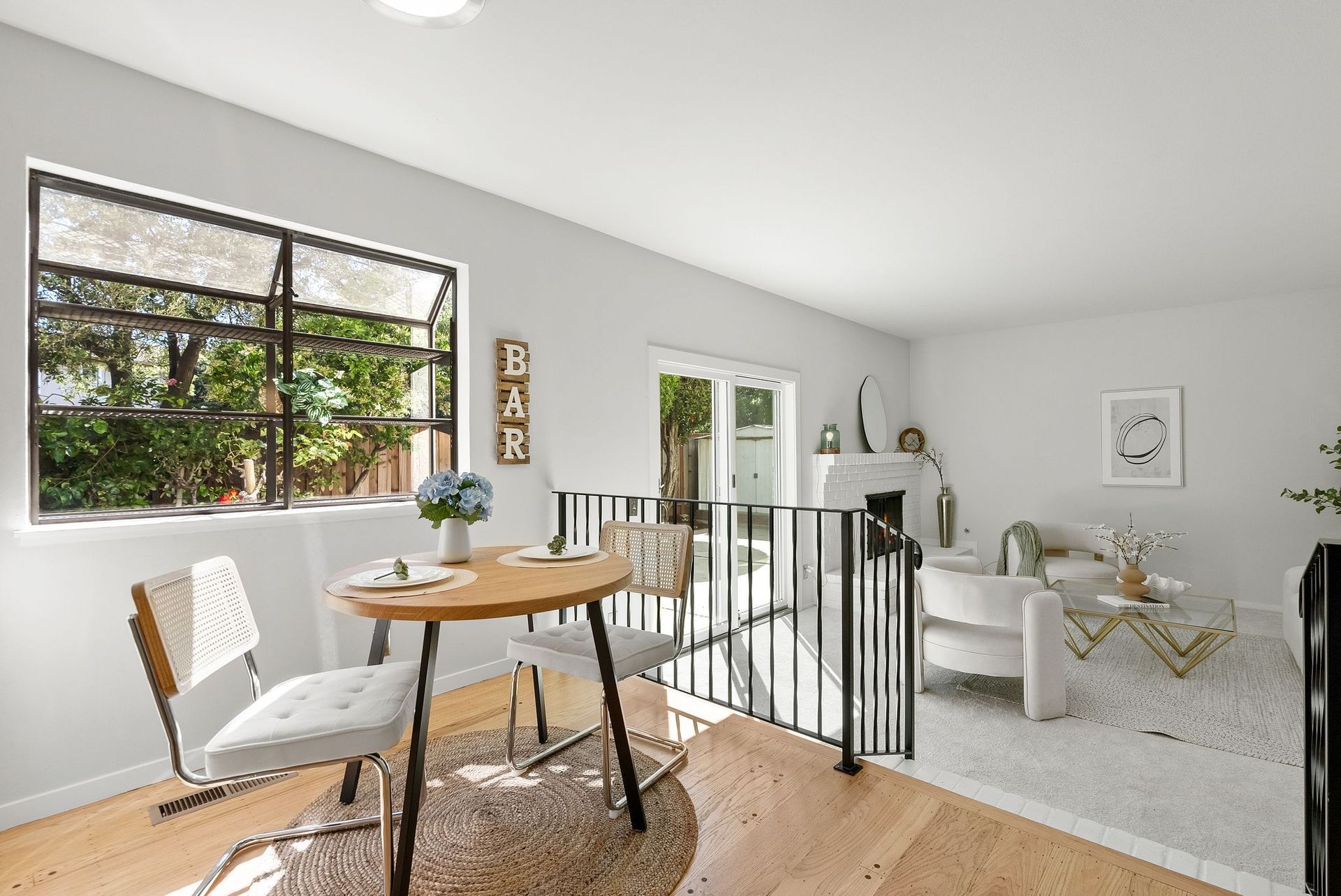 A living room with a table and chairs and a window.