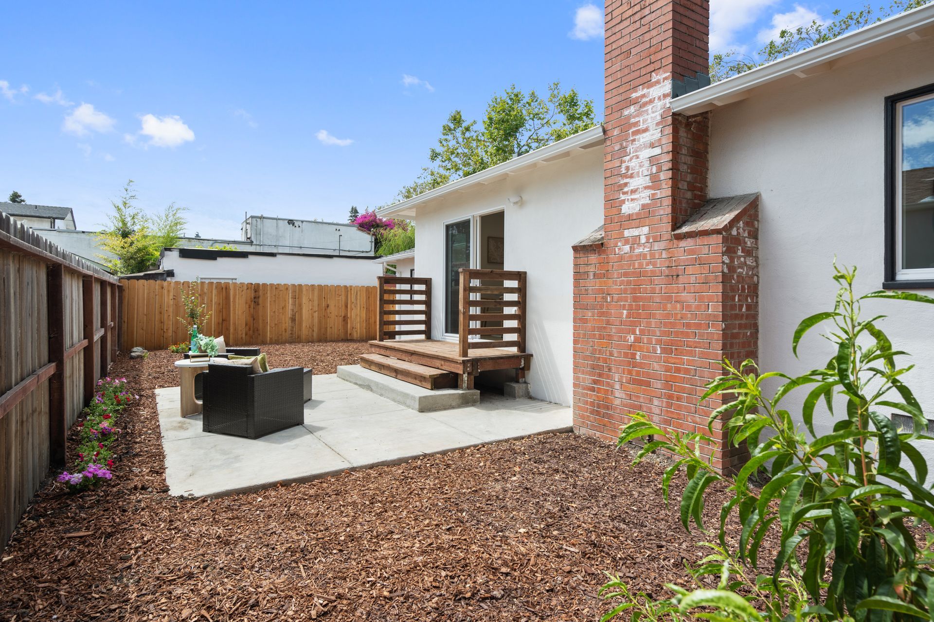 The backyard of a house with a brick chimney and a patio.