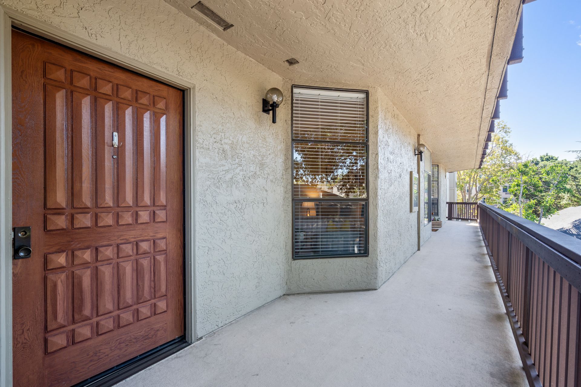 A long hallway with a wooden door and a window