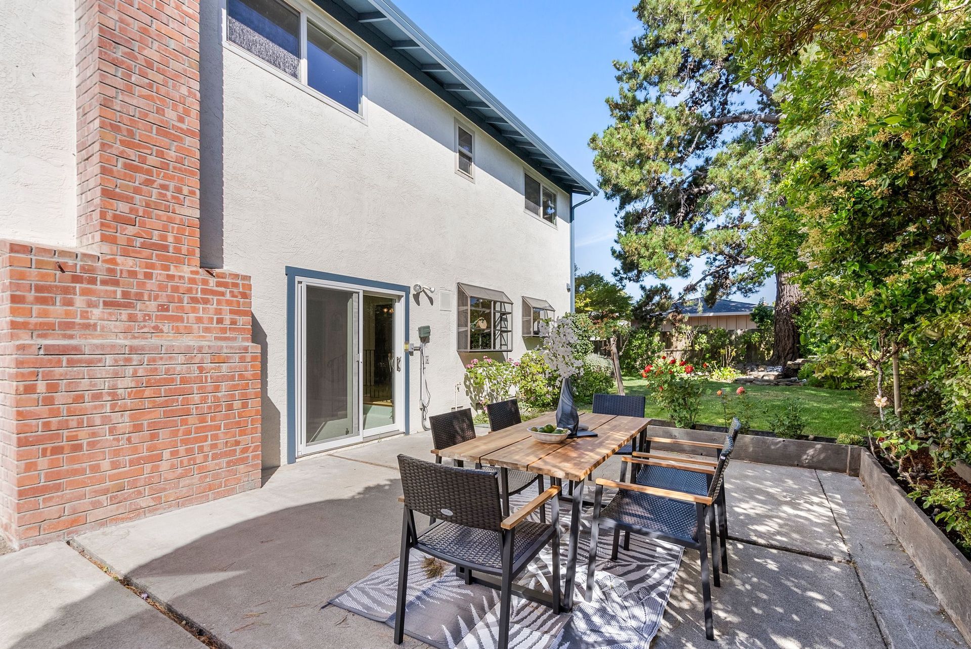 A patio with a table and chairs in front of a house.