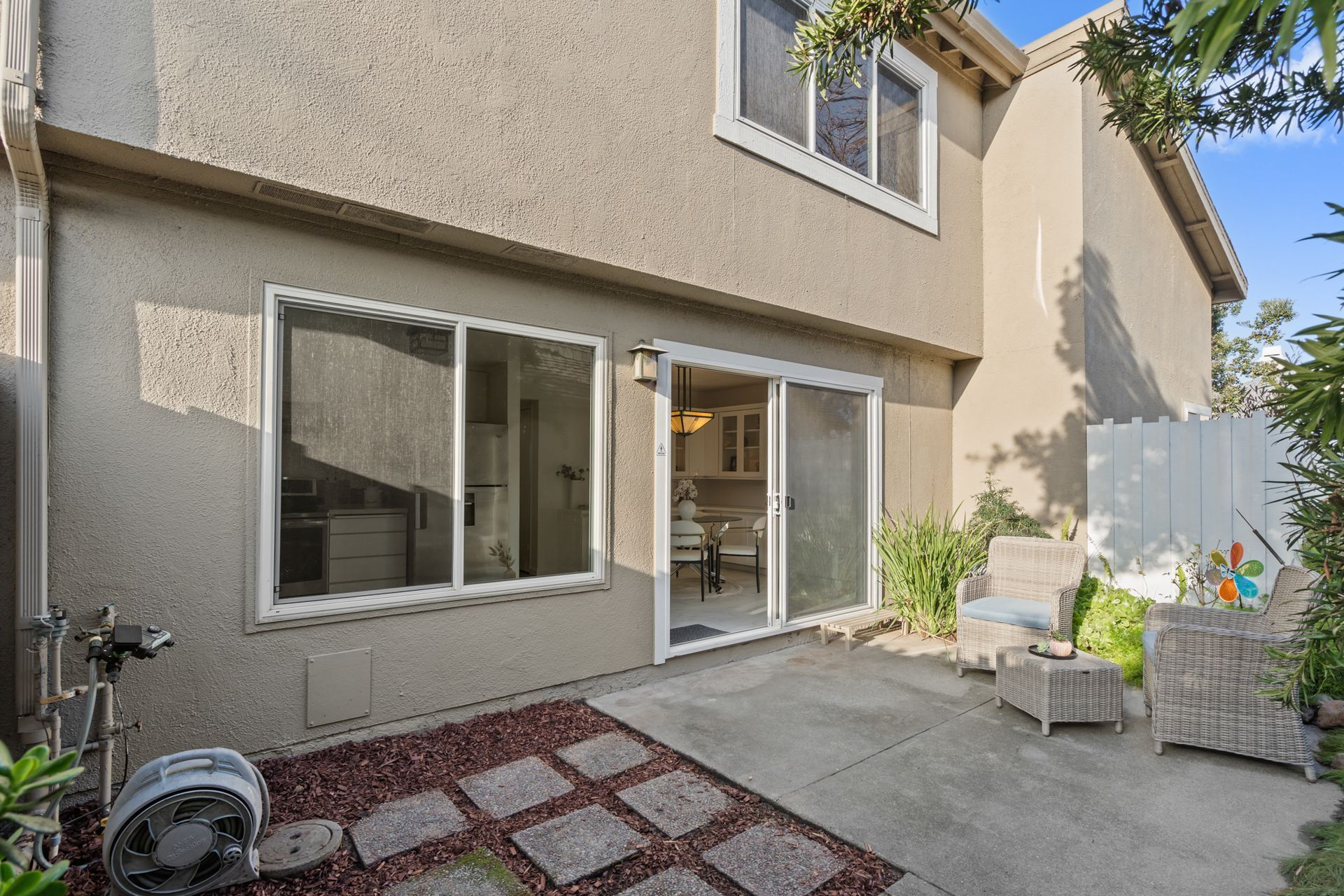 The backyard of a house with a patio and sliding glass doors.