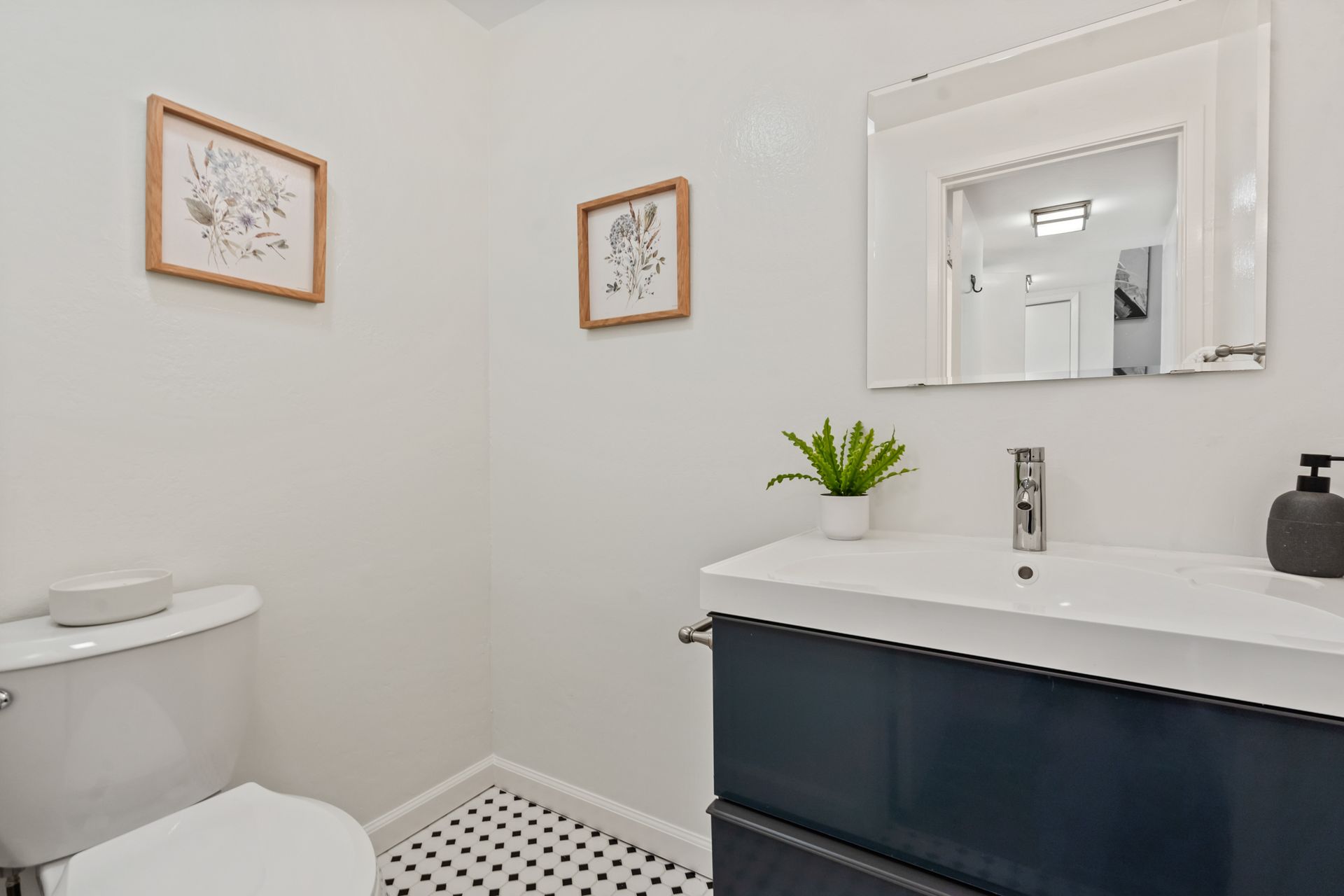 A bathroom with a toilet , sink and mirror.
