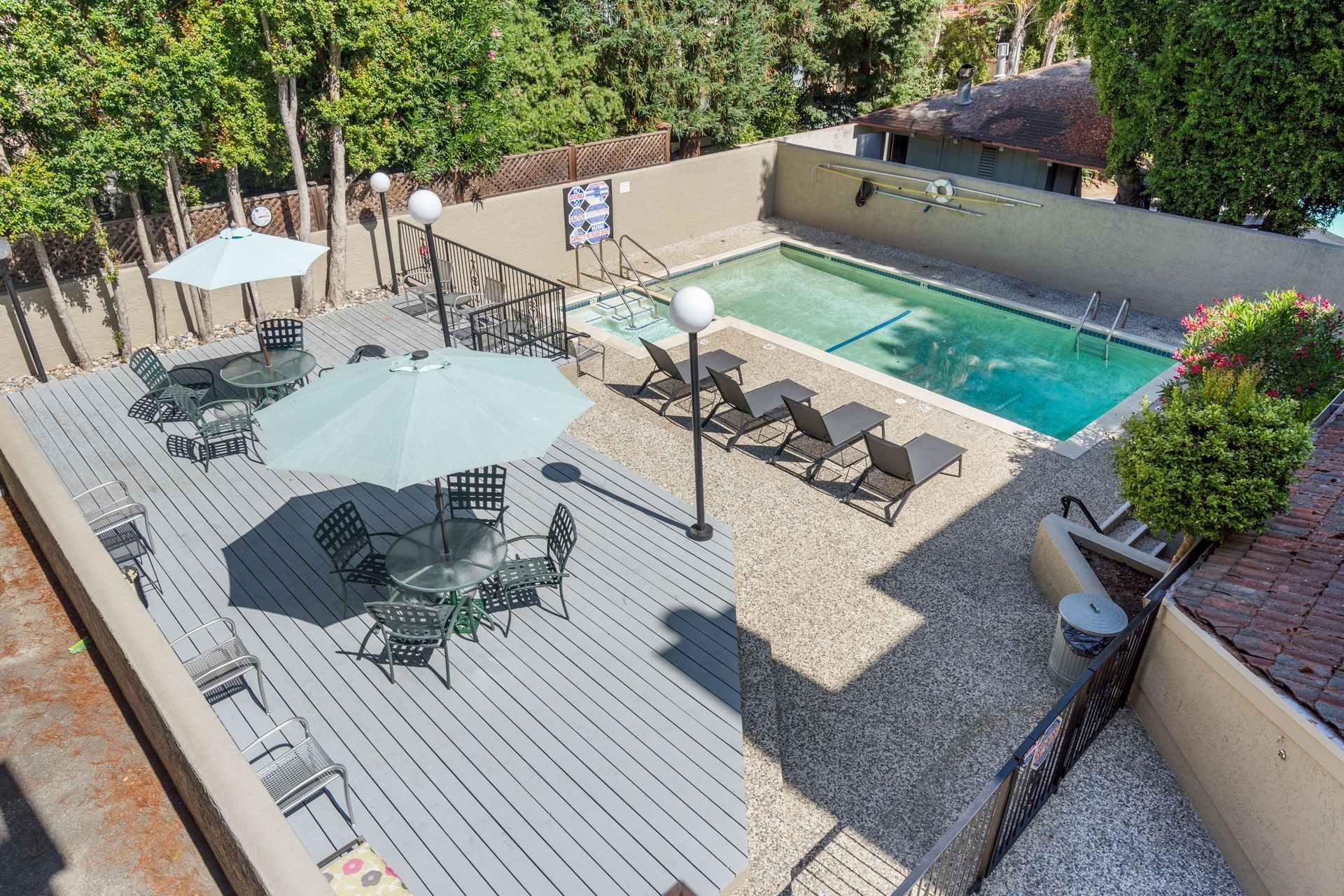 An aerial view of a swimming pool with umbrellas and chairs.