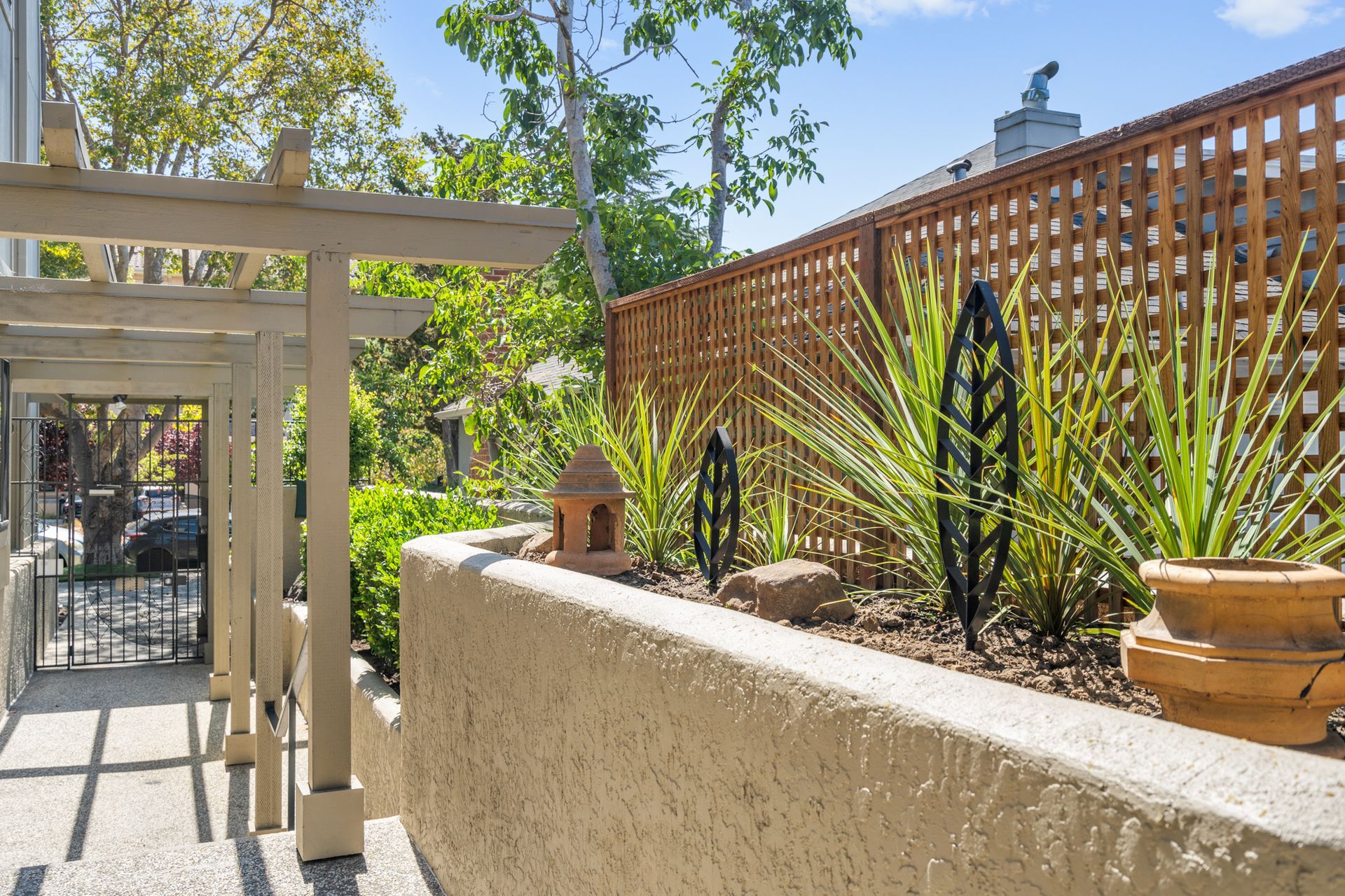 A garden with a wooden fence and potted plants