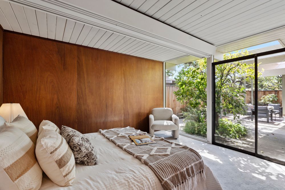 Calm primary bedroom with patio views, dual closets, and ensuite bath — Rumana Jabeen & Associates emphasize comfort for buyers and marketing strength for sellers