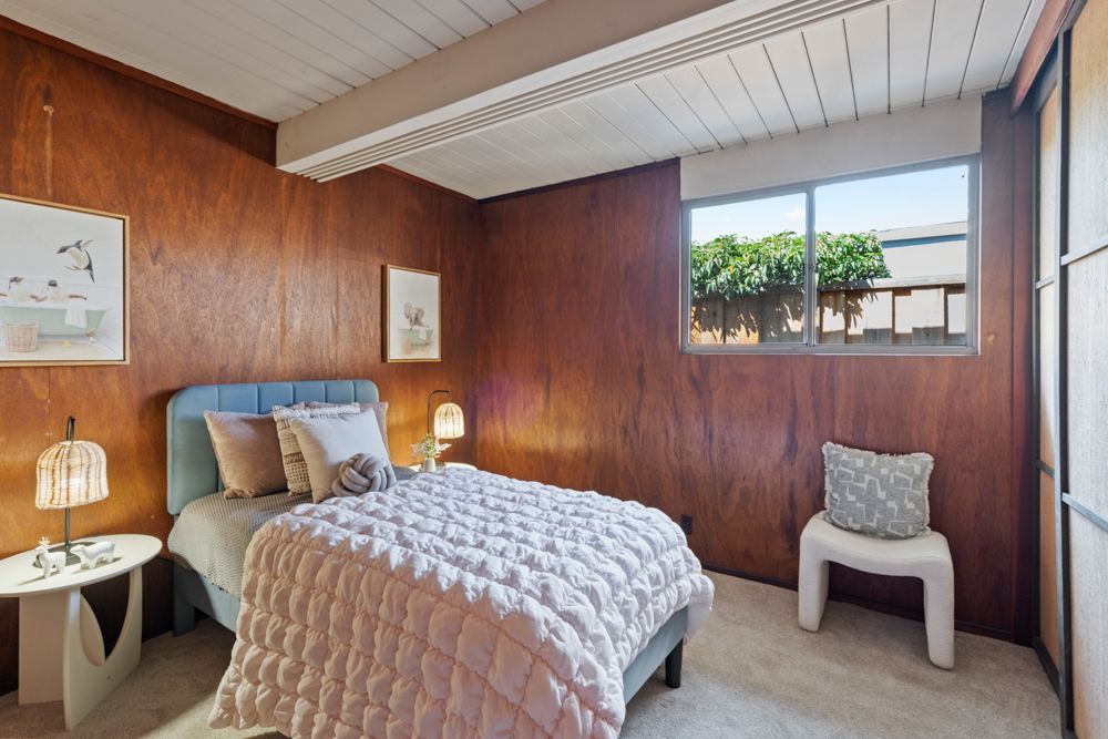 Bright secondary bedroom with large window and mid-century details, highlighted by Rumana Jabeen & Associates to inspire buyers and show sellers thoughtful presentation.