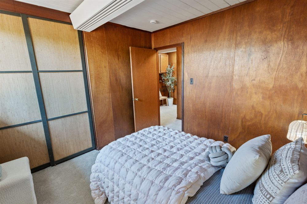 Bright secondary bedroom with large window and mid-century details, highlighted by Rumana Jabeen & Associates to inspire buyers and show sellers thoughtful presentation.