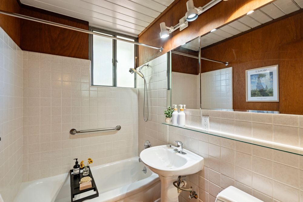 Well-designed hallway bathroom with shower-over-tub, featured by Rumana Jabeen & Associates to emphasize everyday convenience for buyers and careful detail for sellers.
