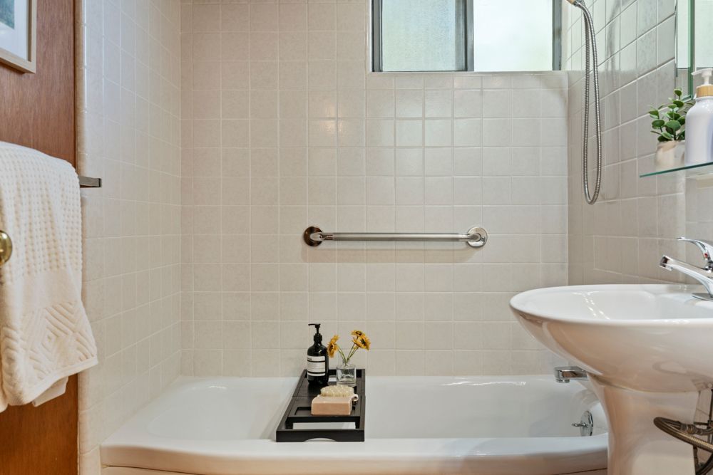 Well-designed hallway bathroom with shower-over-tub, featured by Rumana Jabeen & Associates to emphasize everyday convenience for buyers and careful detail for sellers.