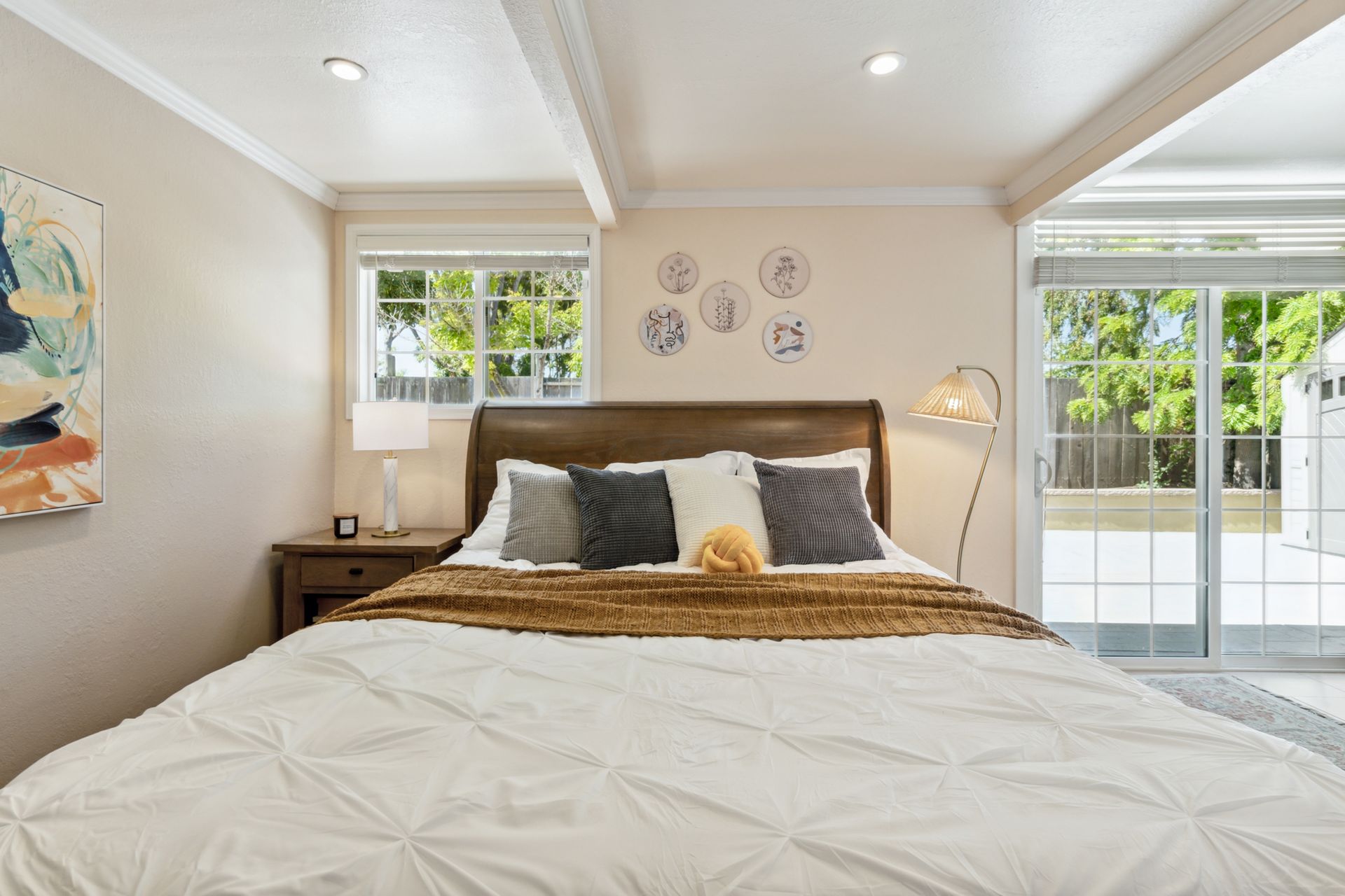 A bedroom with a king size bed and a sliding glass door.