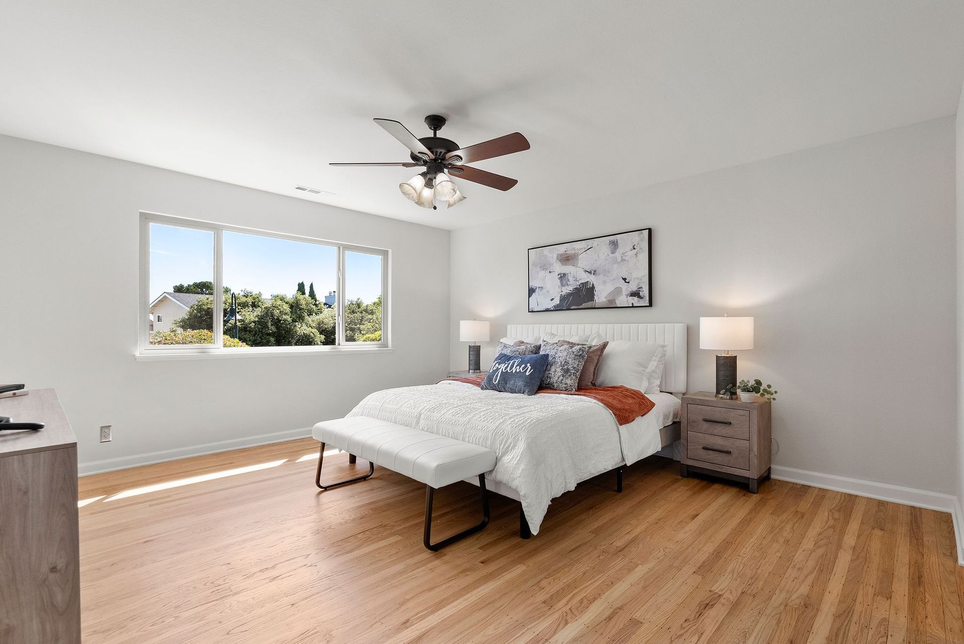 A bedroom with a bed and a ceiling fan.
