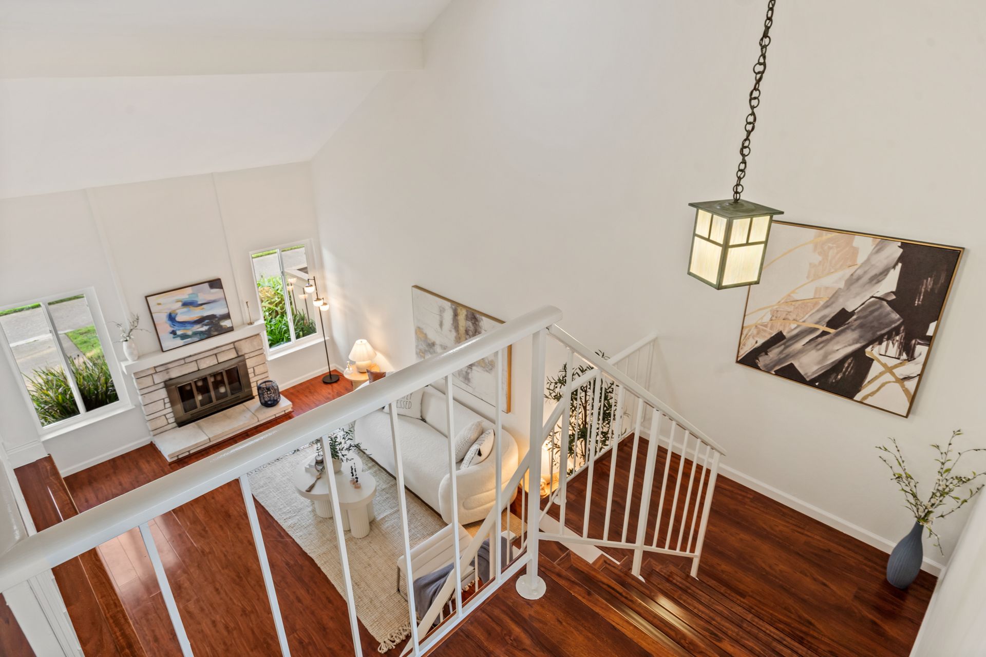 An aerial view of a living room with hardwood floors and a fireplace.