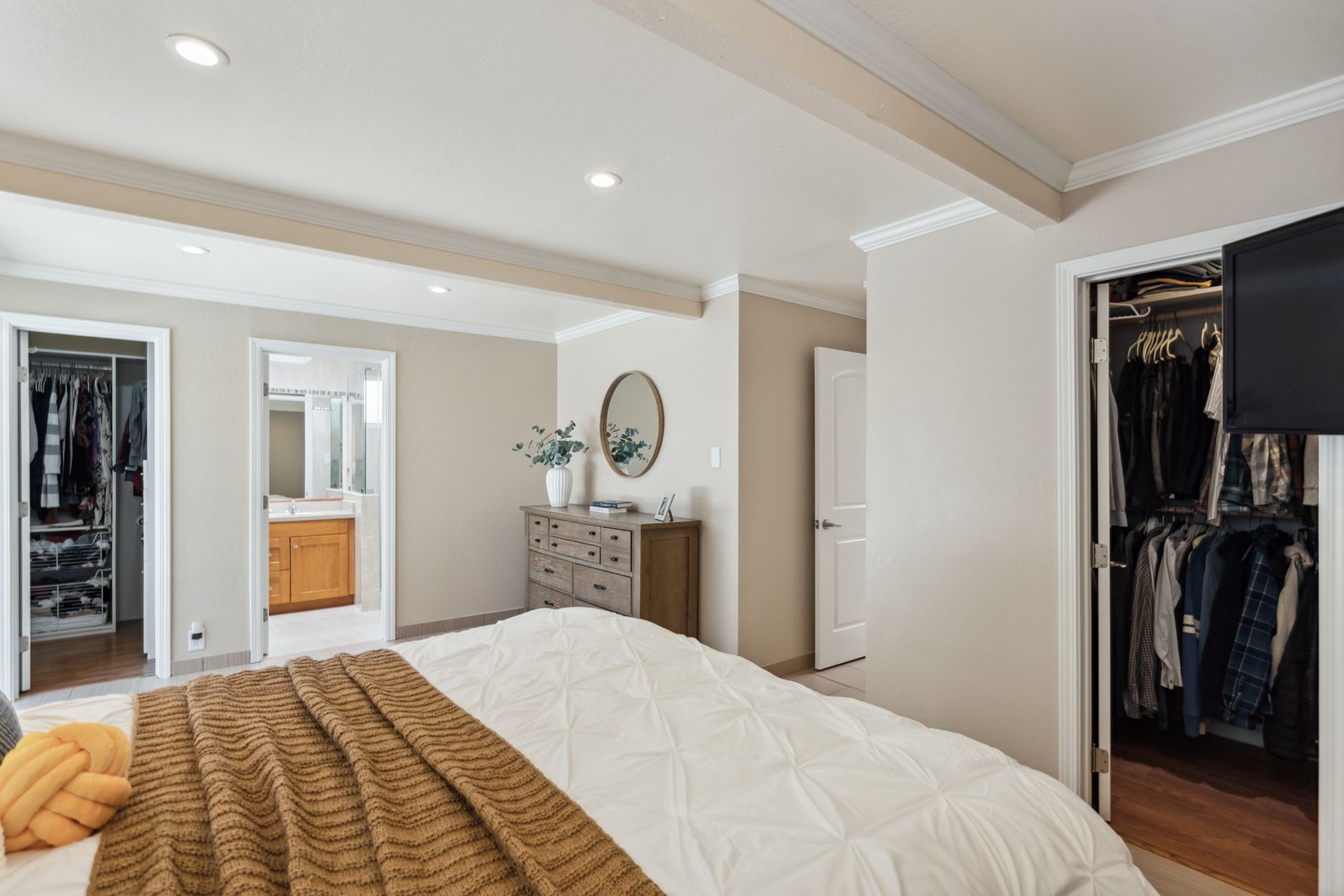 A bedroom with a large bed and a walk in closet.