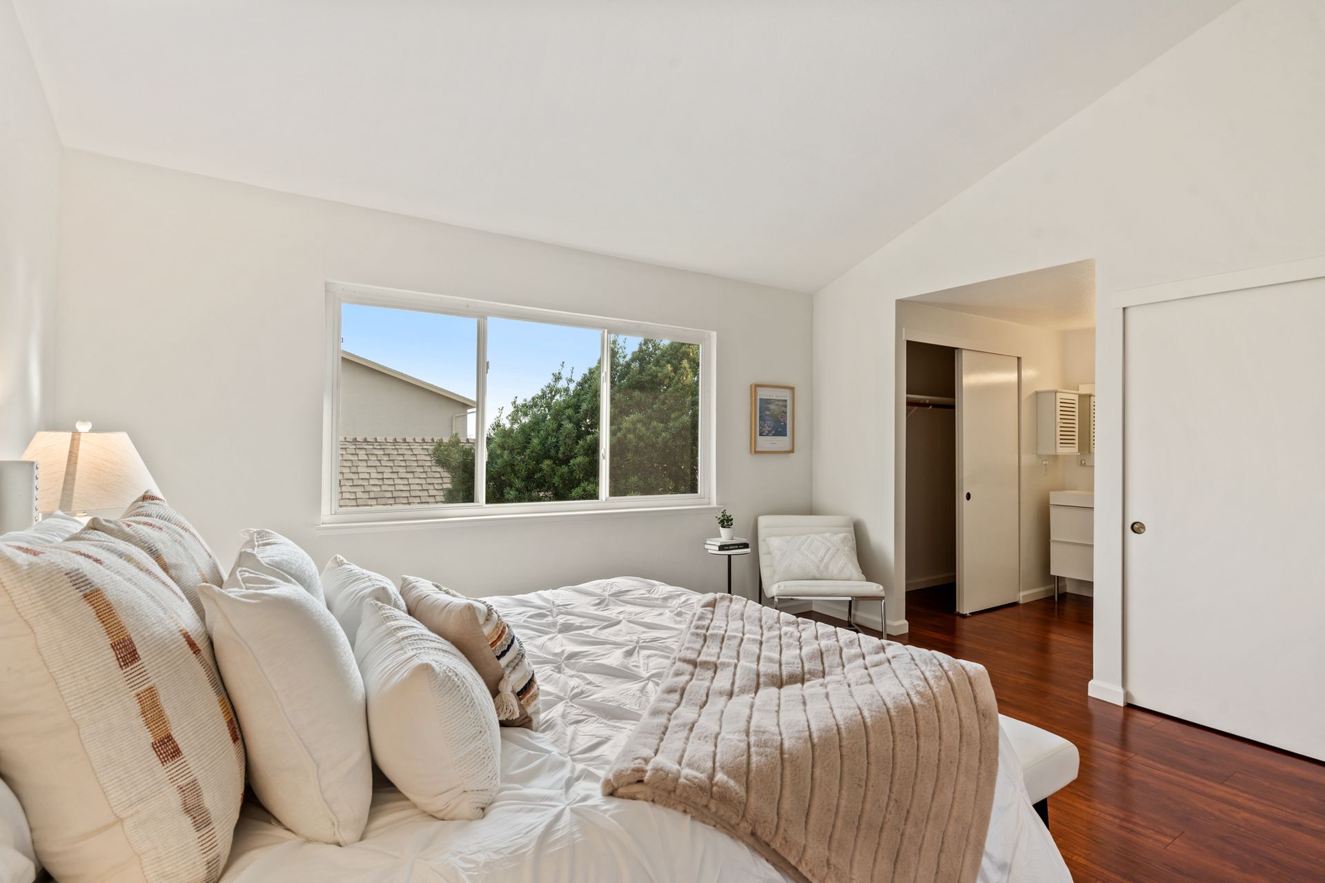 A bedroom with a large bed and a window.
