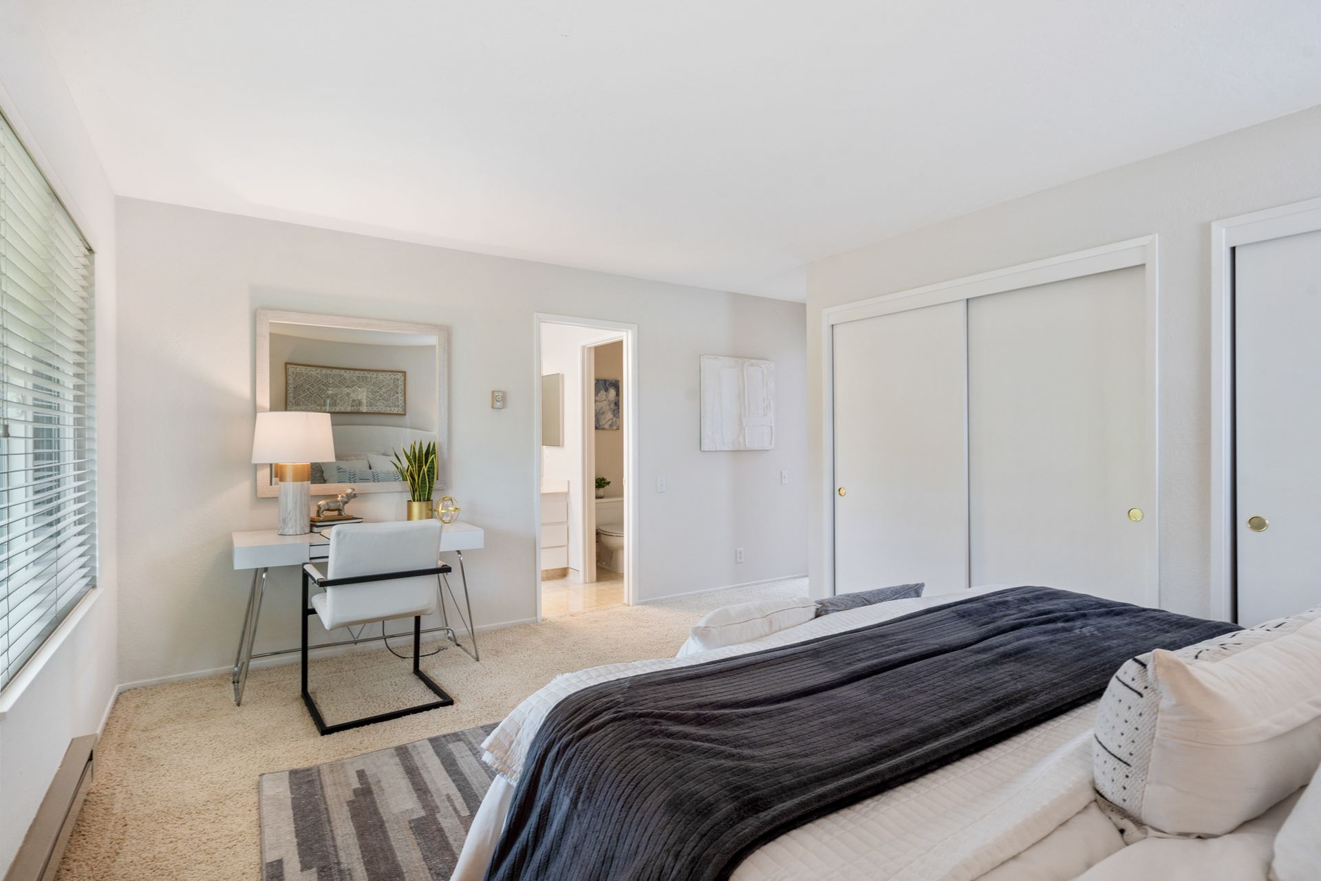 A bedroom with a bed , desk and chair.