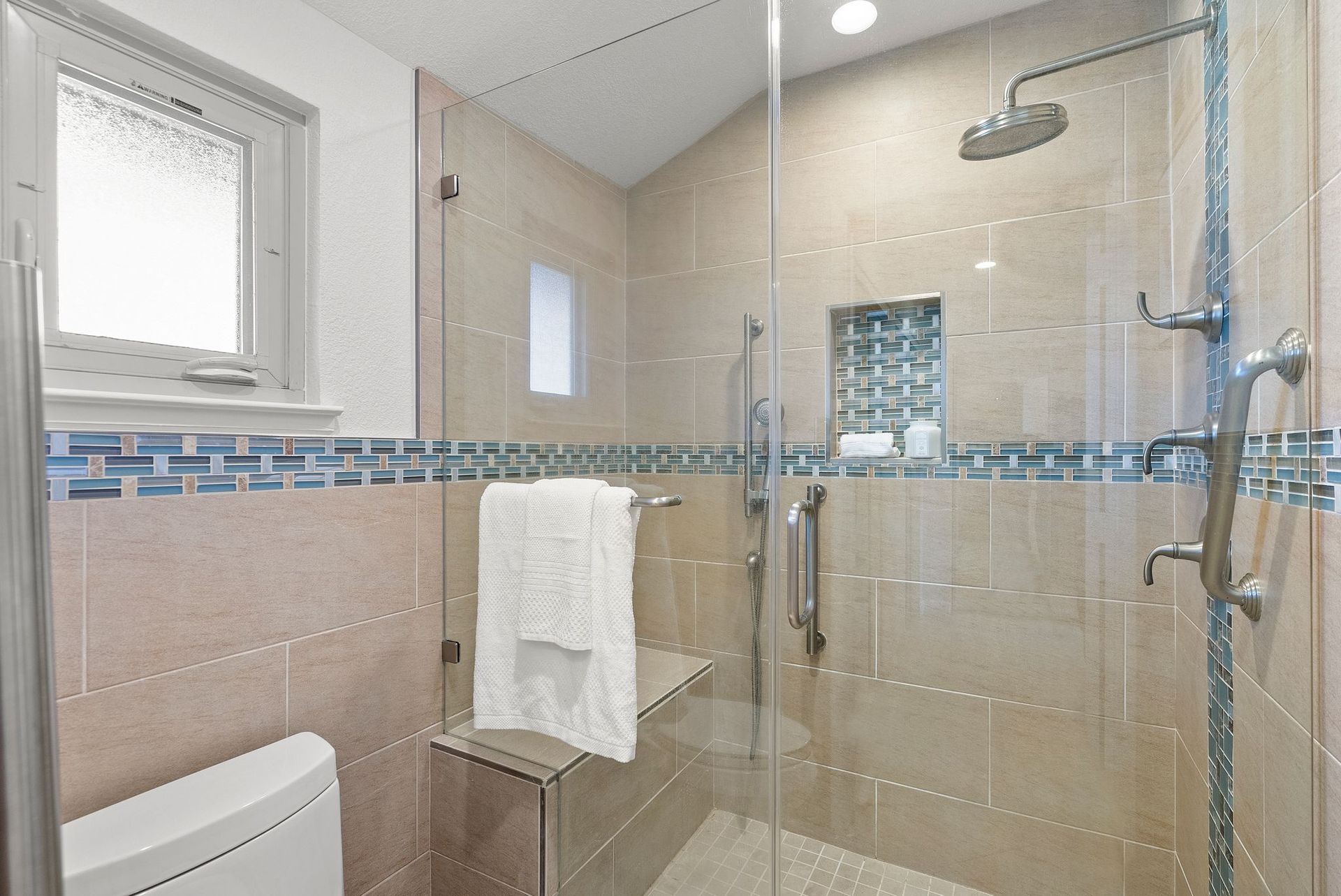 A bathroom with a walk in shower and a toilet.