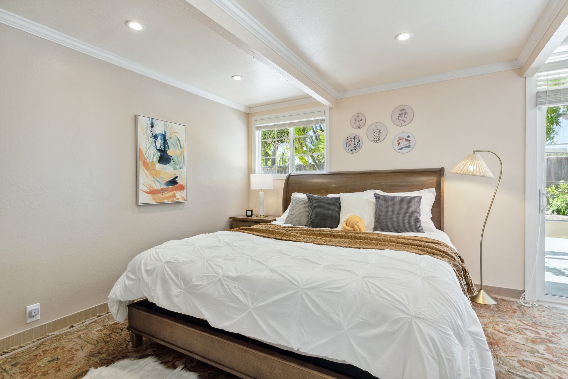 A bedroom with a large bed and a painting on the wall.