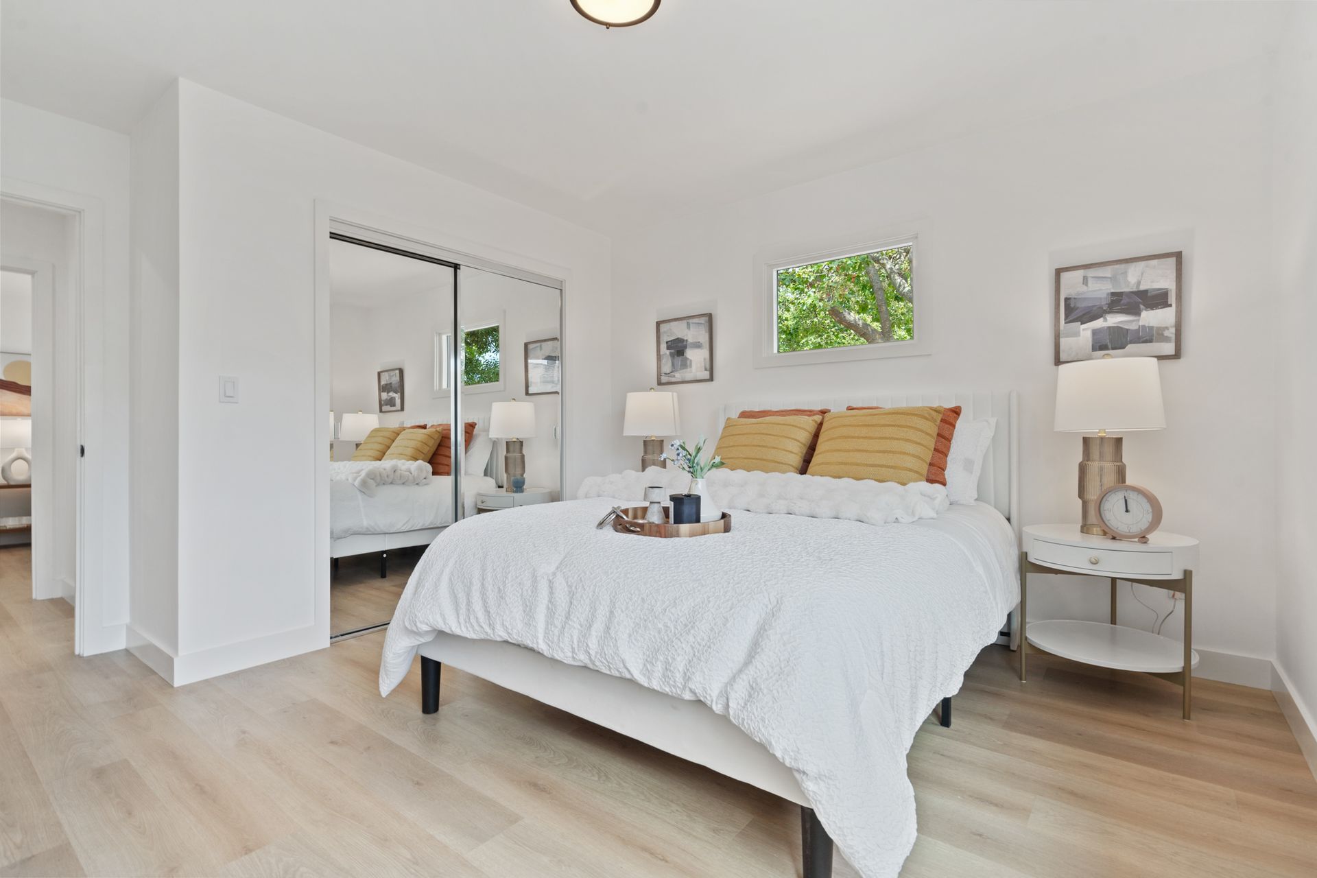 A bedroom with a bed , nightstands , lamps and a sliding glass door.