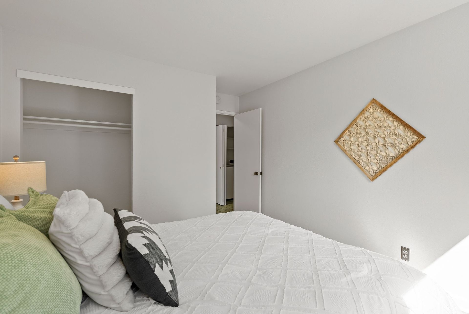 A bedroom with a large bed and a closet.