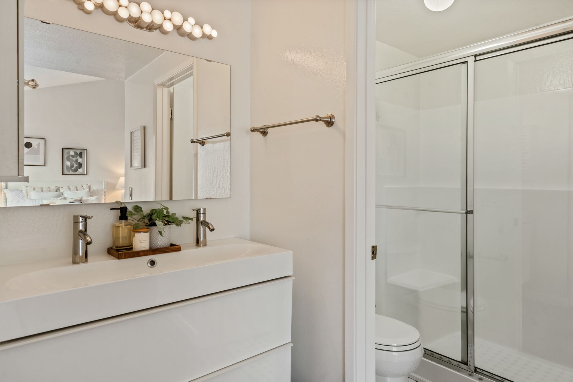 A bathroom with a sink , toilet , shower and mirror.