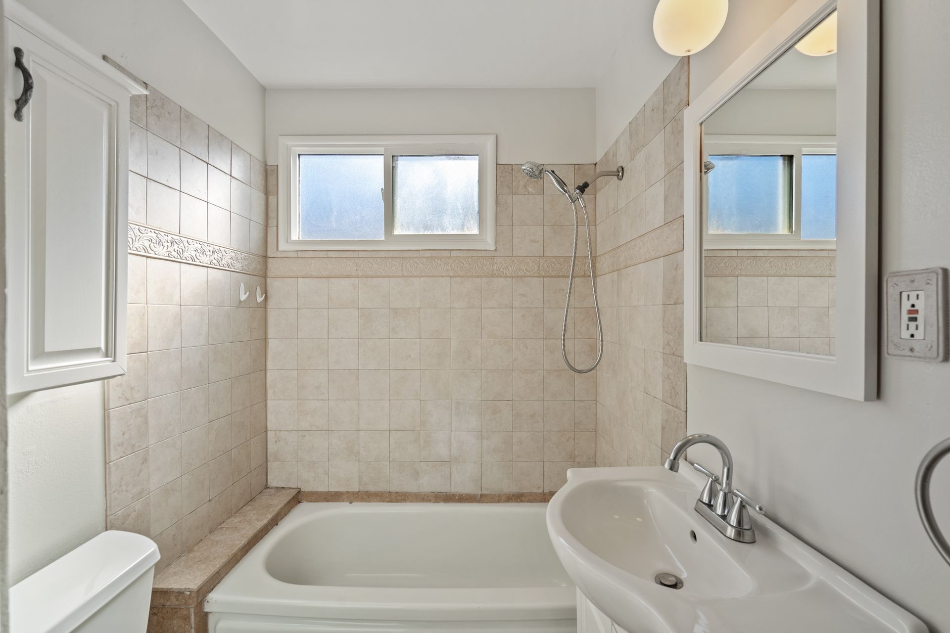 A bathroom with a tub a sink and a mirror