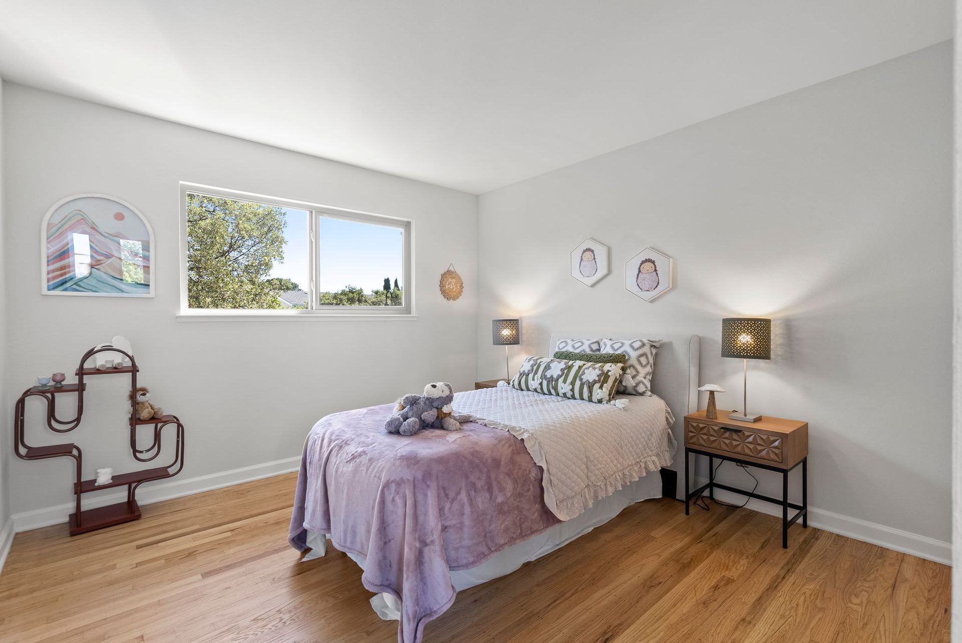 A bedroom with a bed , nightstand , and two windows.