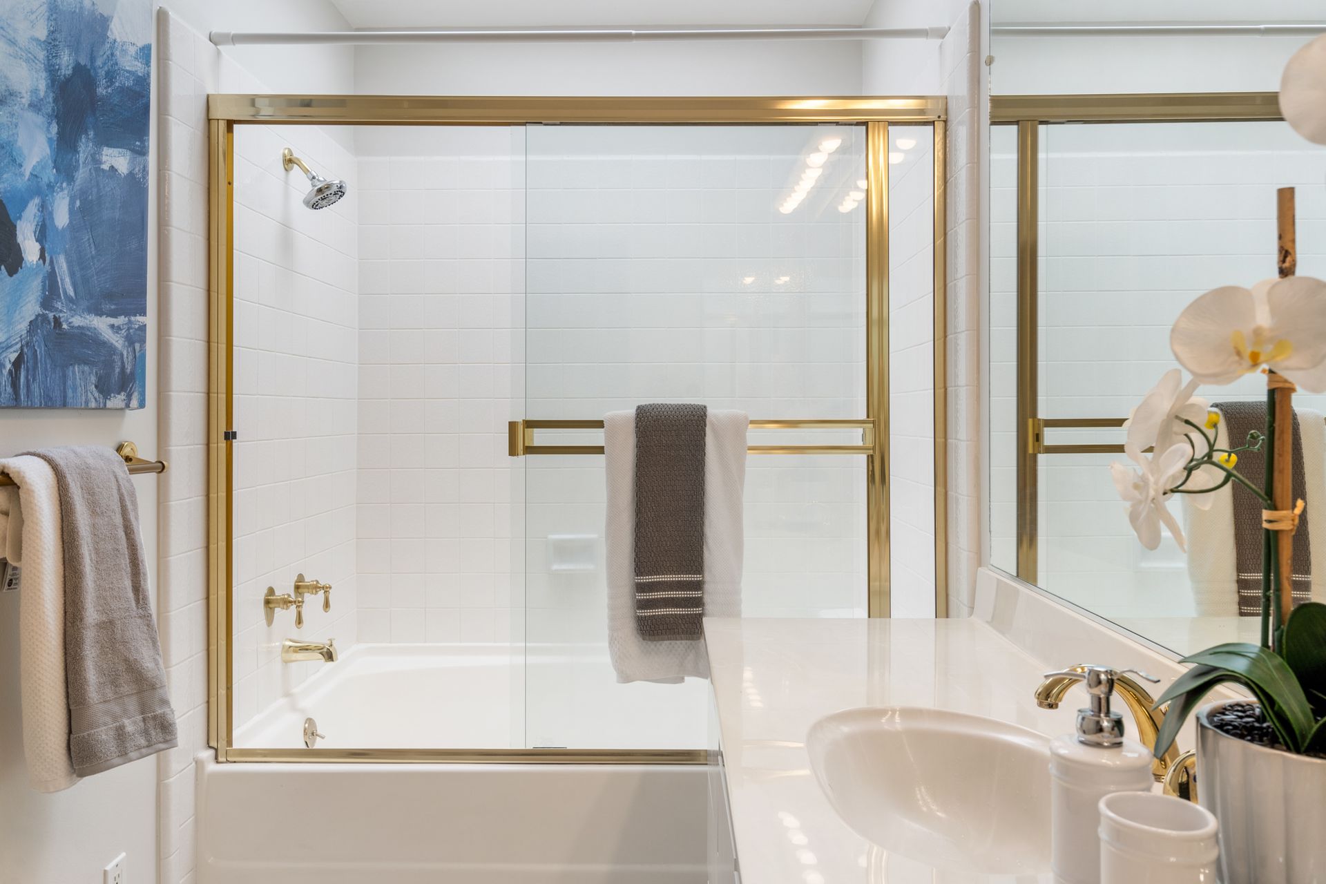 A bathroom with a sink , tub , shower and mirror.