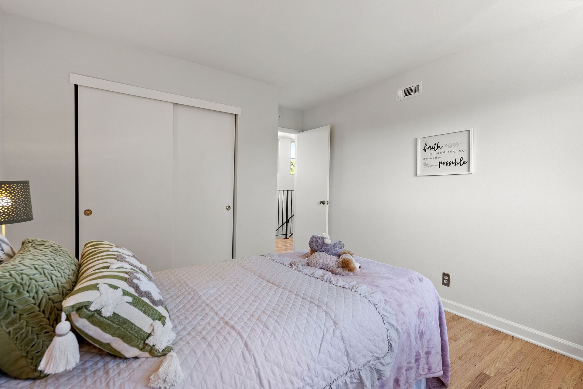 A bedroom with a bed , closet and lamp.