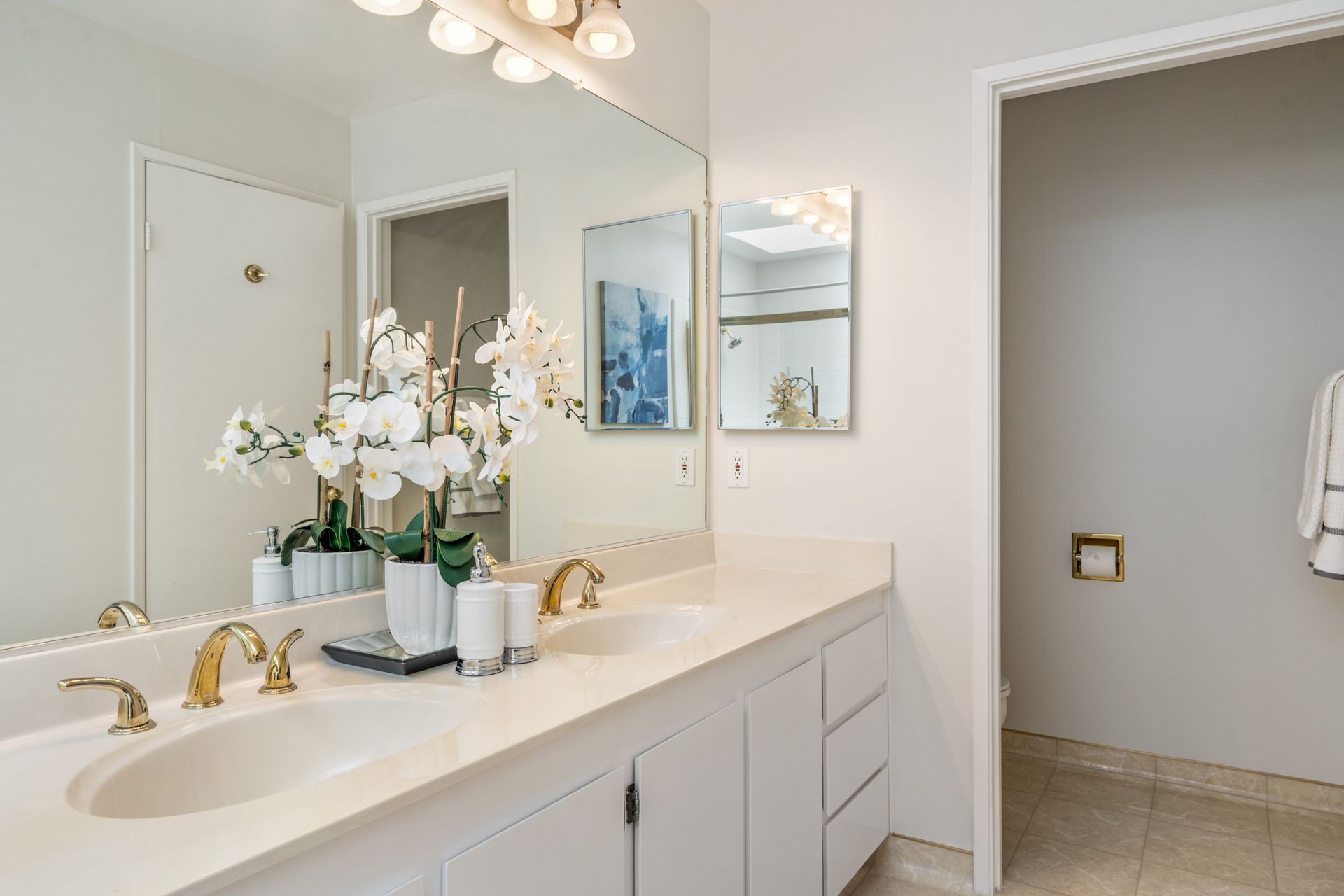 A bathroom with two sinks and a large mirror.