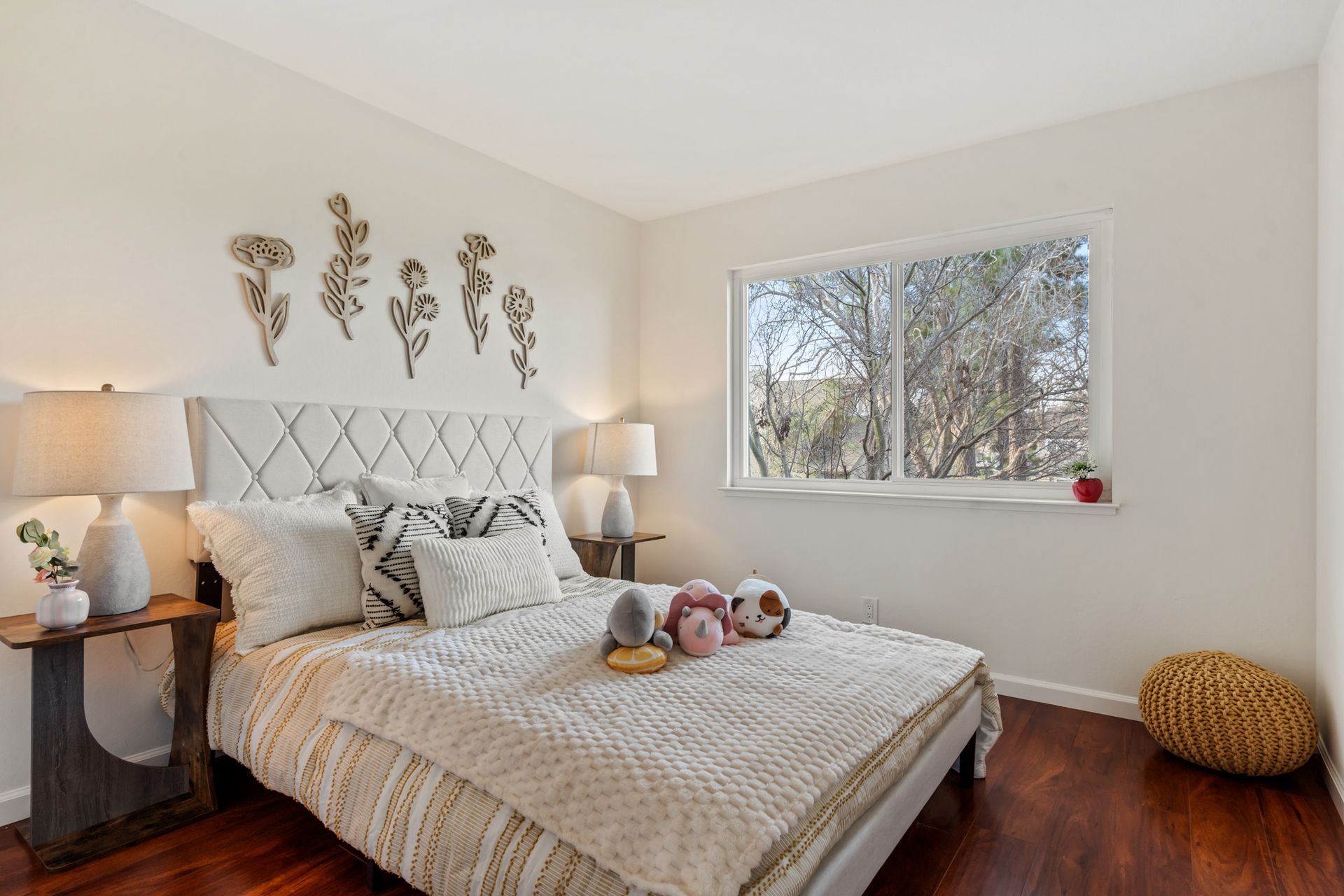 A bedroom with a bed , lamps , and a window.