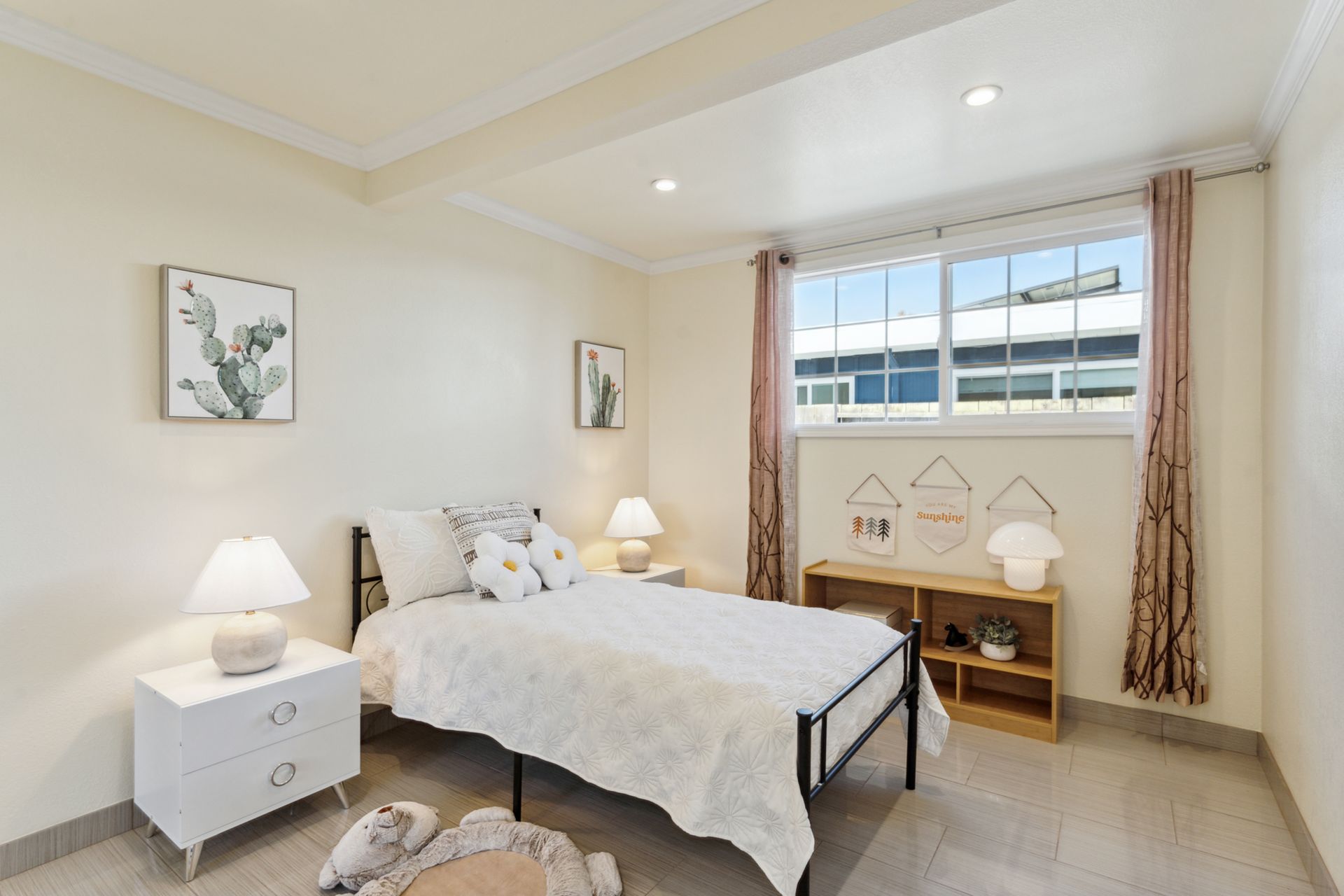 A bedroom with a bed , nightstand , lamps and a window.