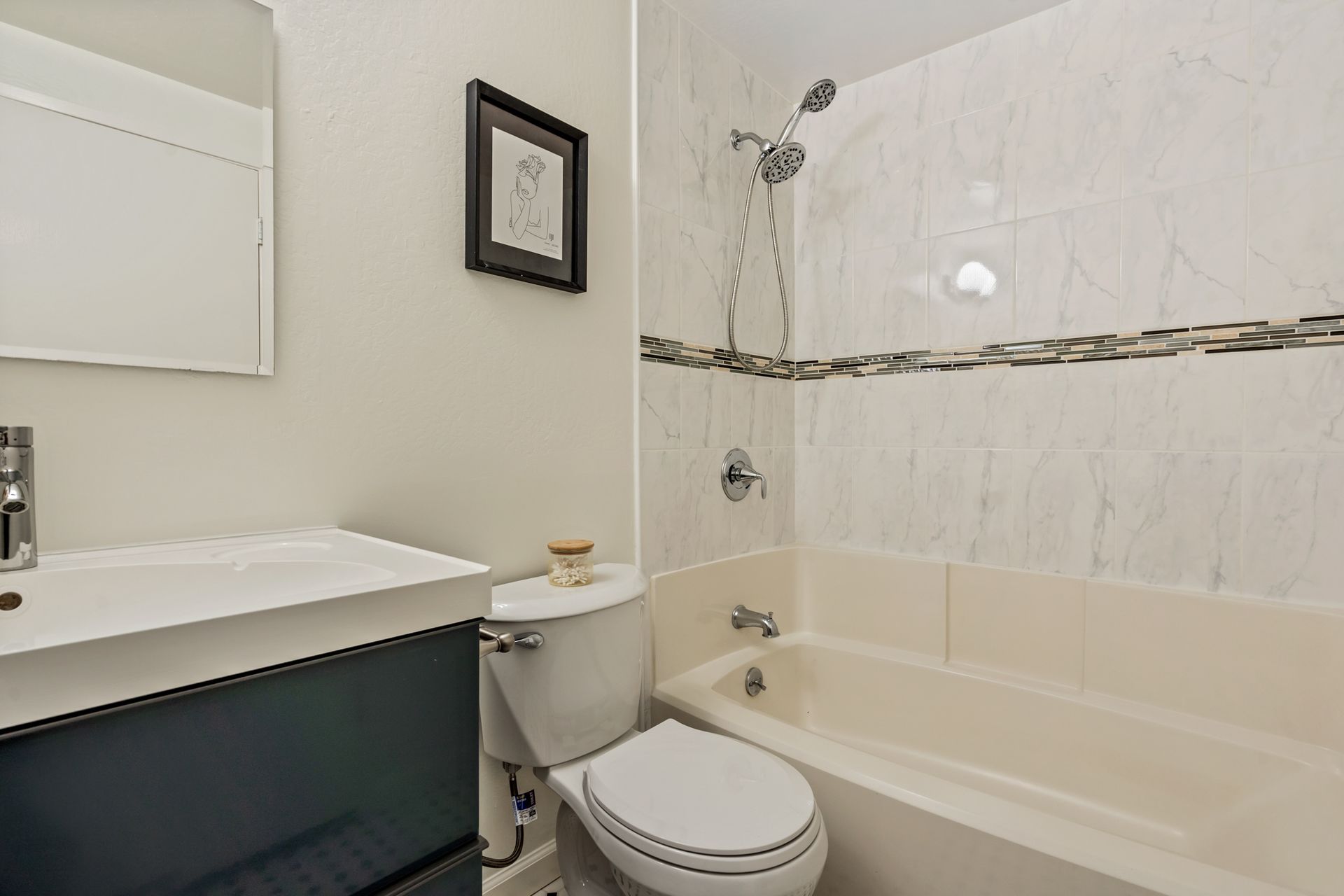 A bathroom with a toilet , sink and bathtub.