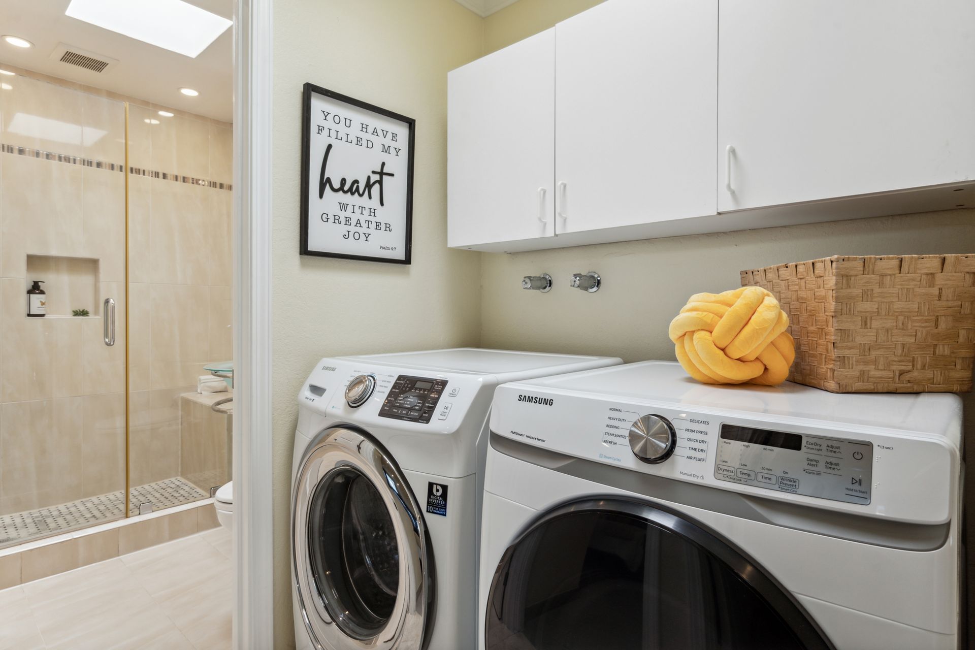 A laundry room with a washer and dryer next to a bathroom.