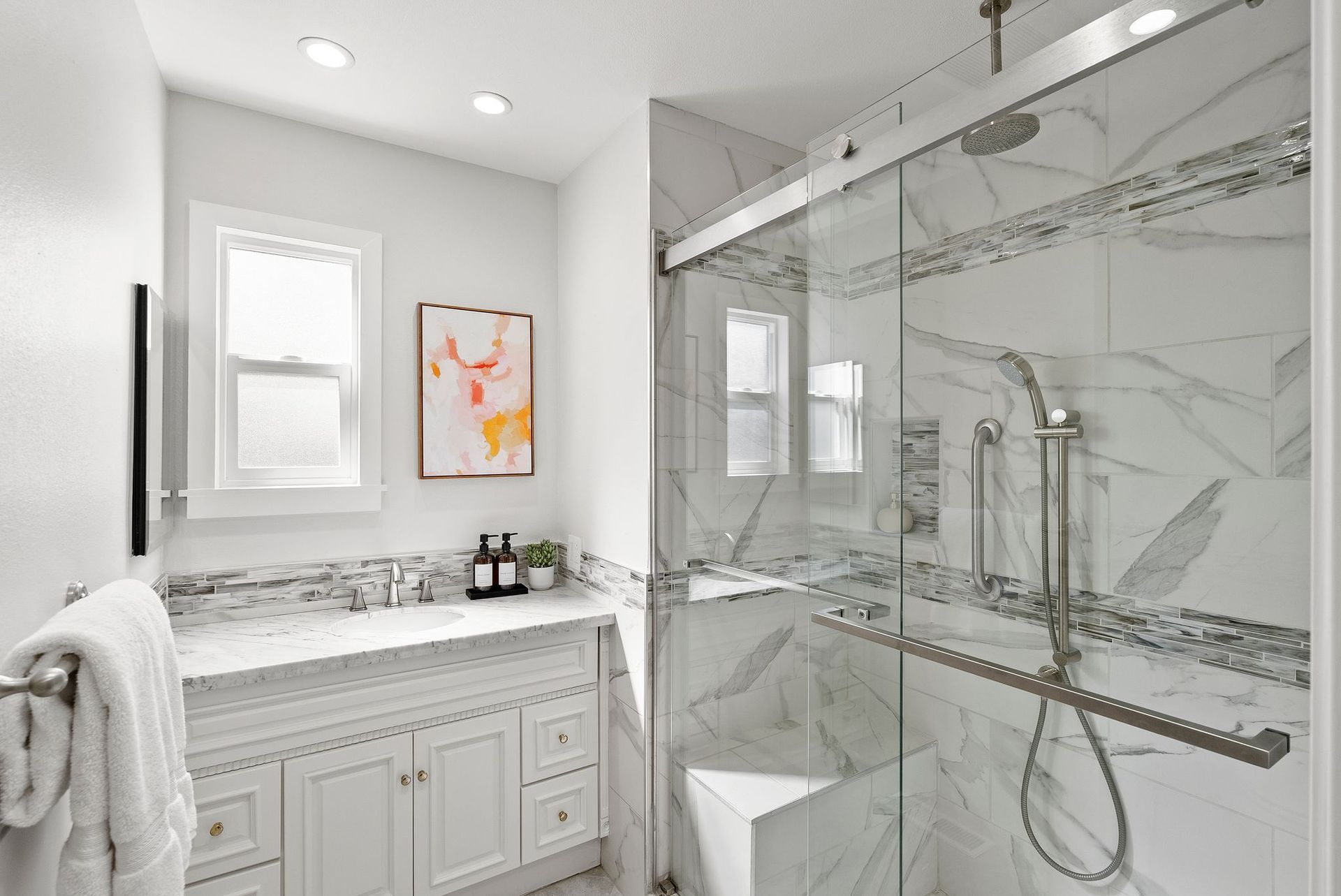 A bathroom with a walk in shower , sink and toilet.