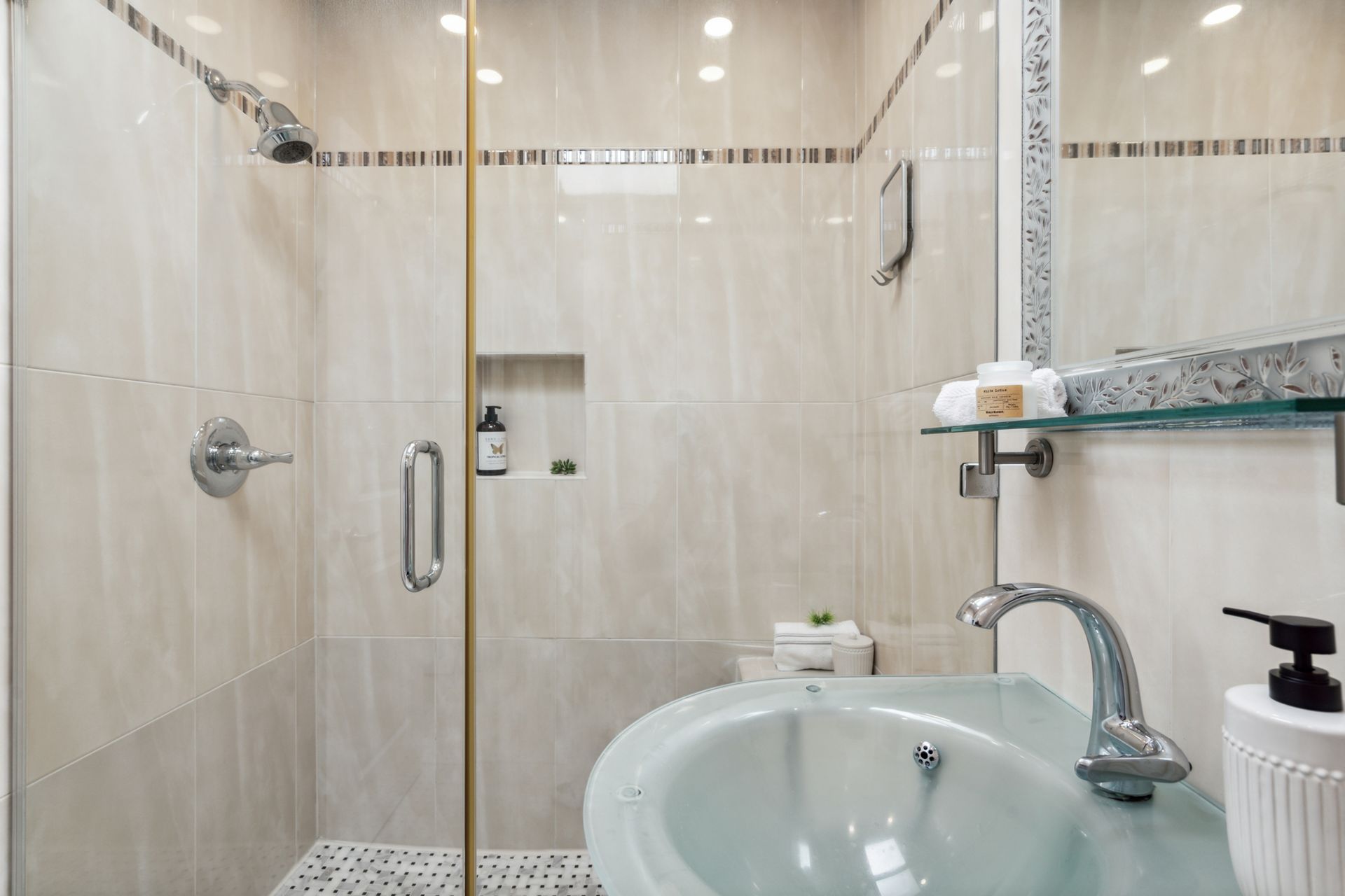 A bathroom with a sink and a walk in shower.