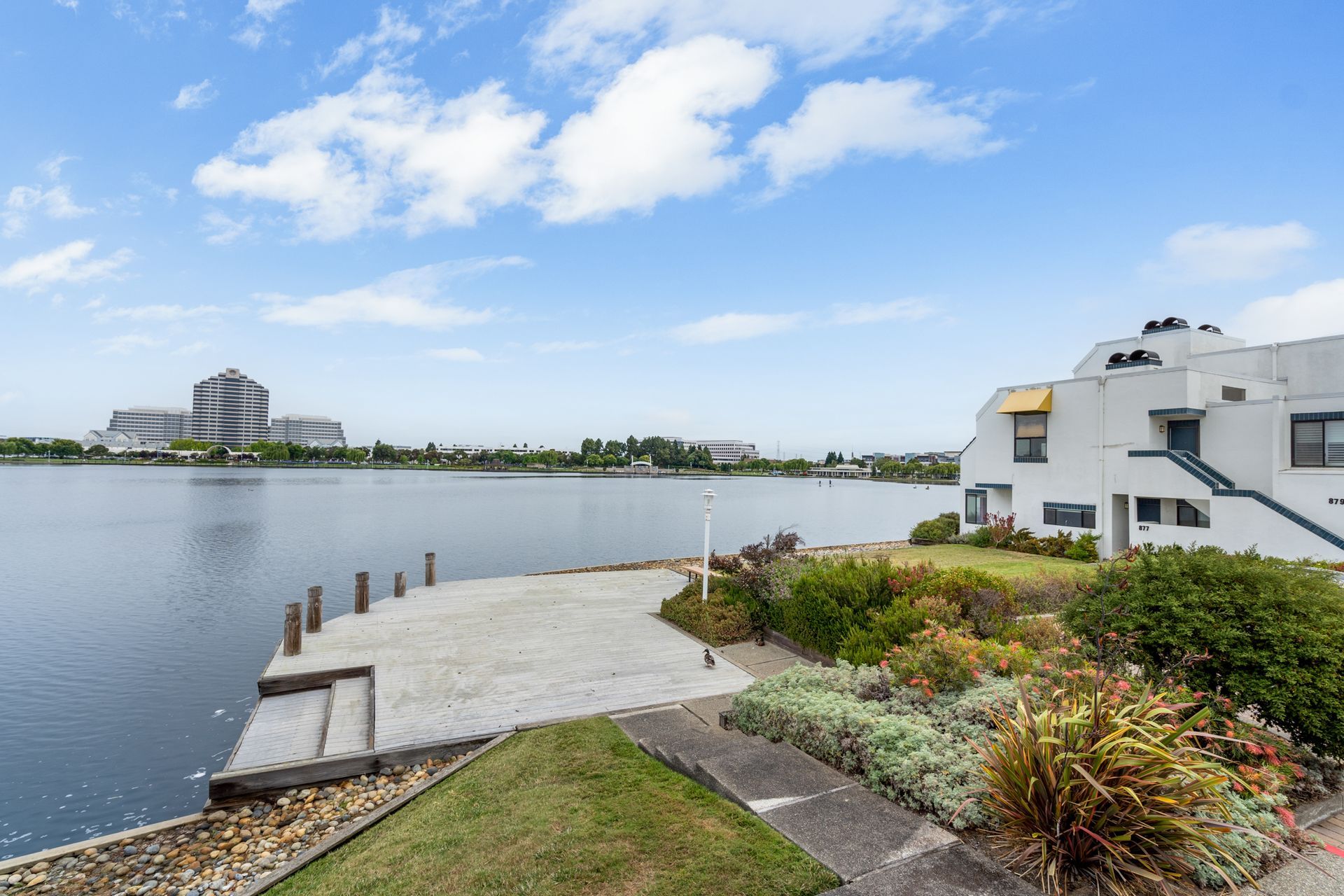 There is a large body of water in the background and a house in the foreground.
