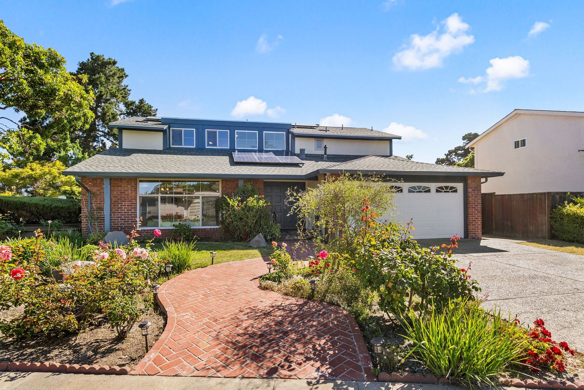 A brick house with a white garage door is for sale