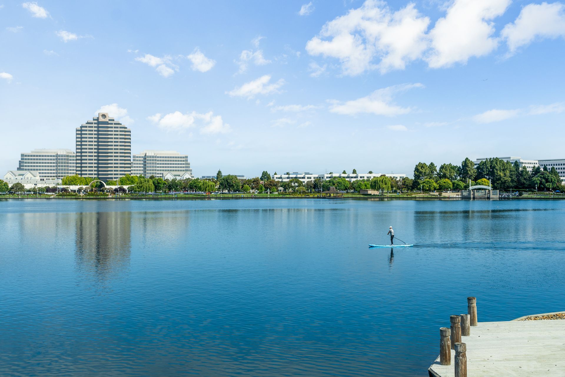 A person is riding a paddle board on a lake.