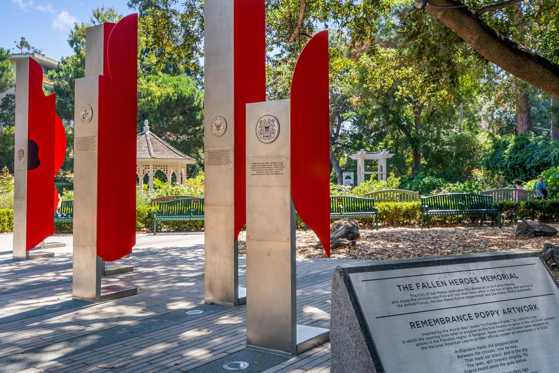 A row of red and silver sculptures in a park.