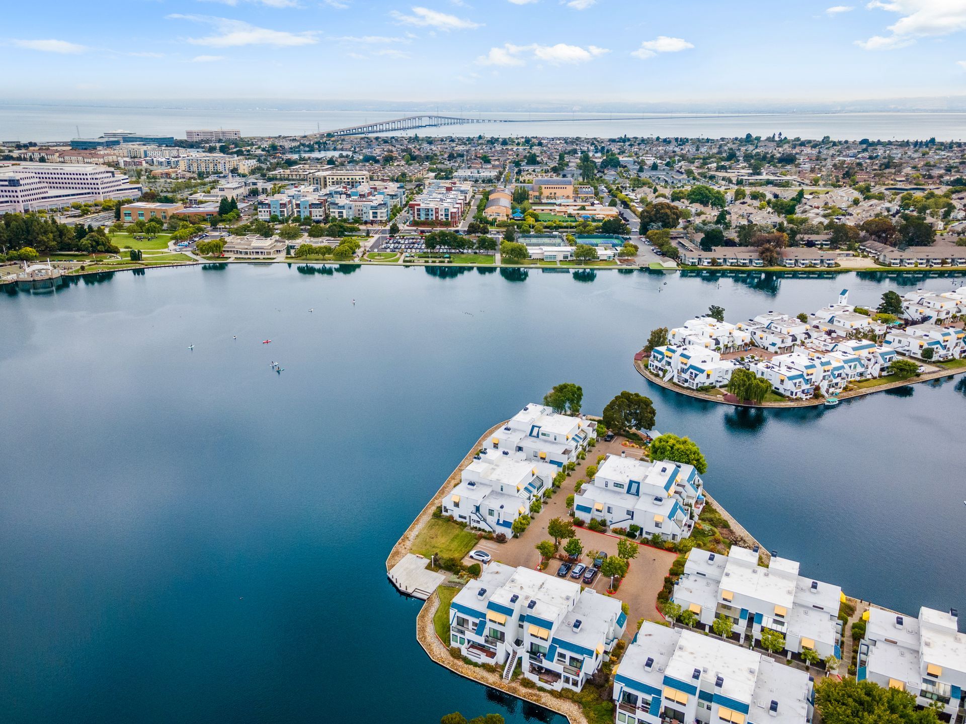 An aerial view of a small island in the middle of a lake surrounded by houses.