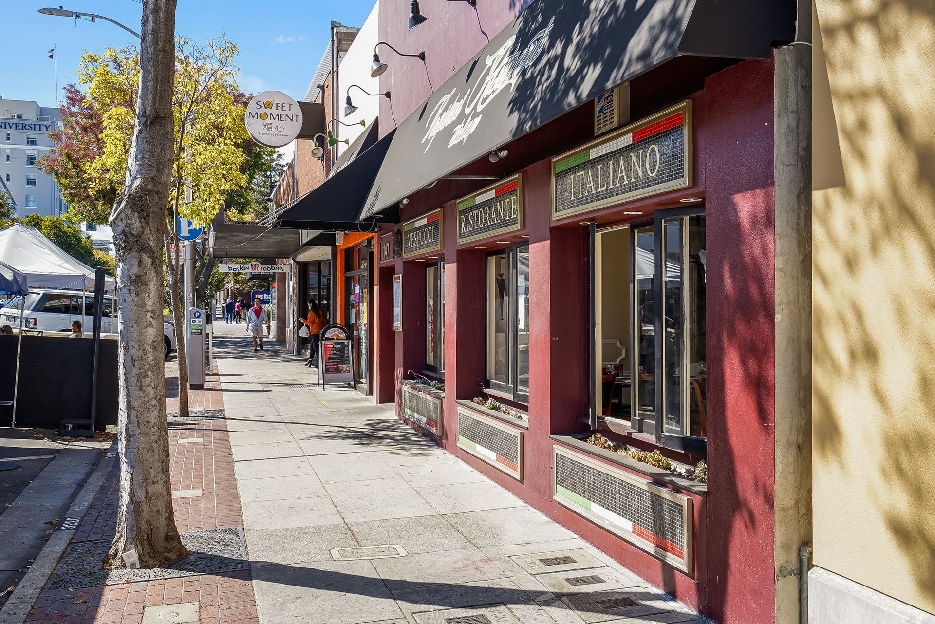 A red building with a black awning on the side of it