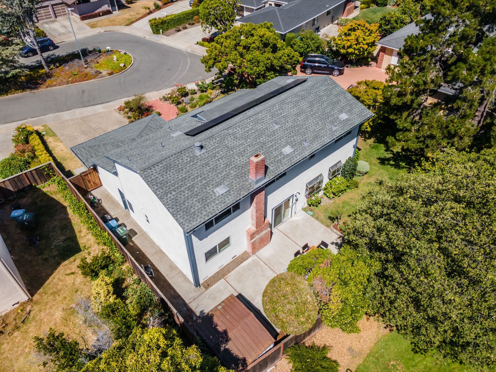 An aerial view of a house with a gray roof